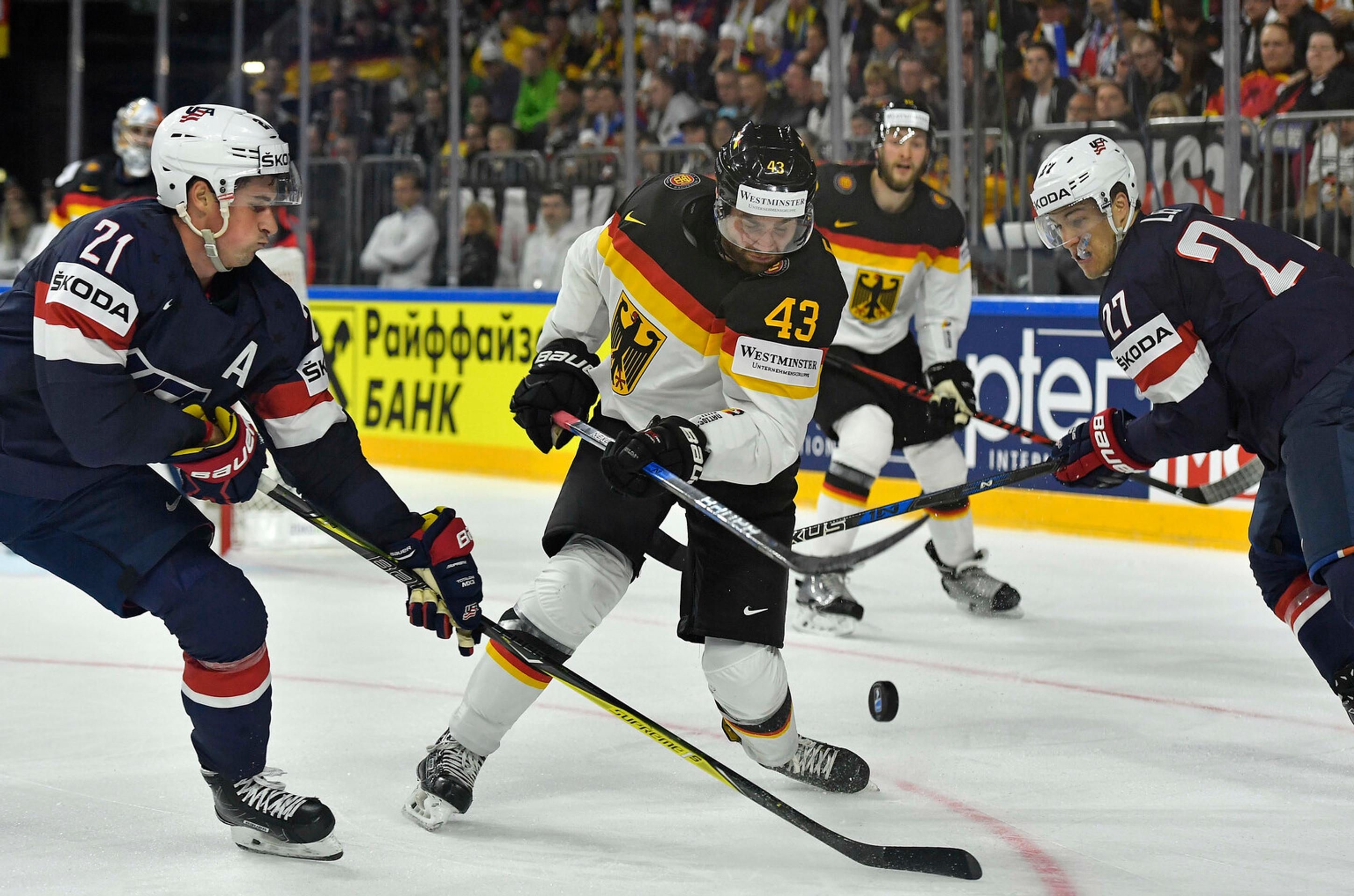Američania Dylan Larkin (vľavo) a Anders Lee stíhajú Nemca Gerrita Fausera na MS 2017.
