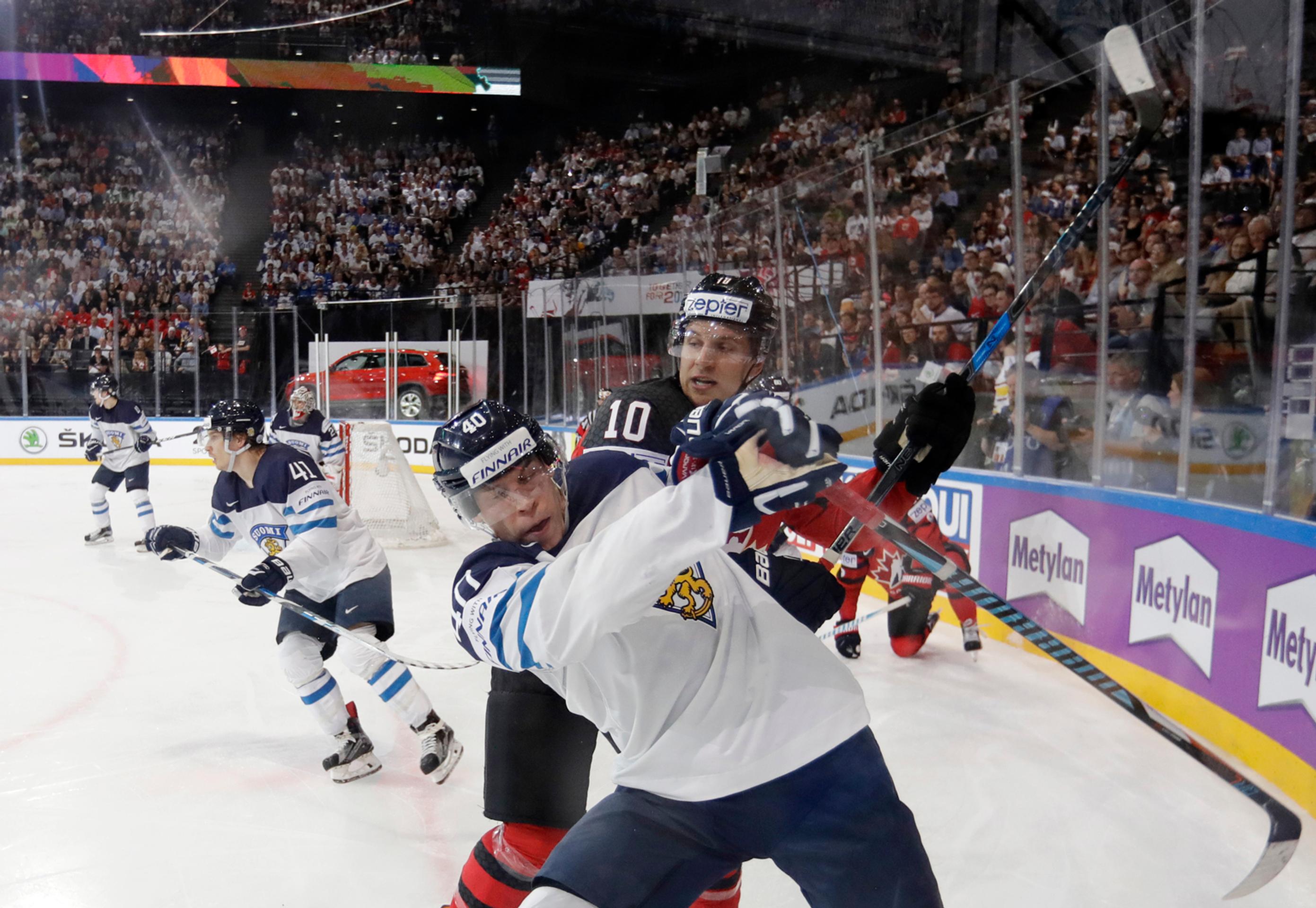 Kanaďan Brayden Schenn (vzadu) v nešetrnom súboji pri mantineli s Fínom Tomim Sallinenom v dueli MS 2017.