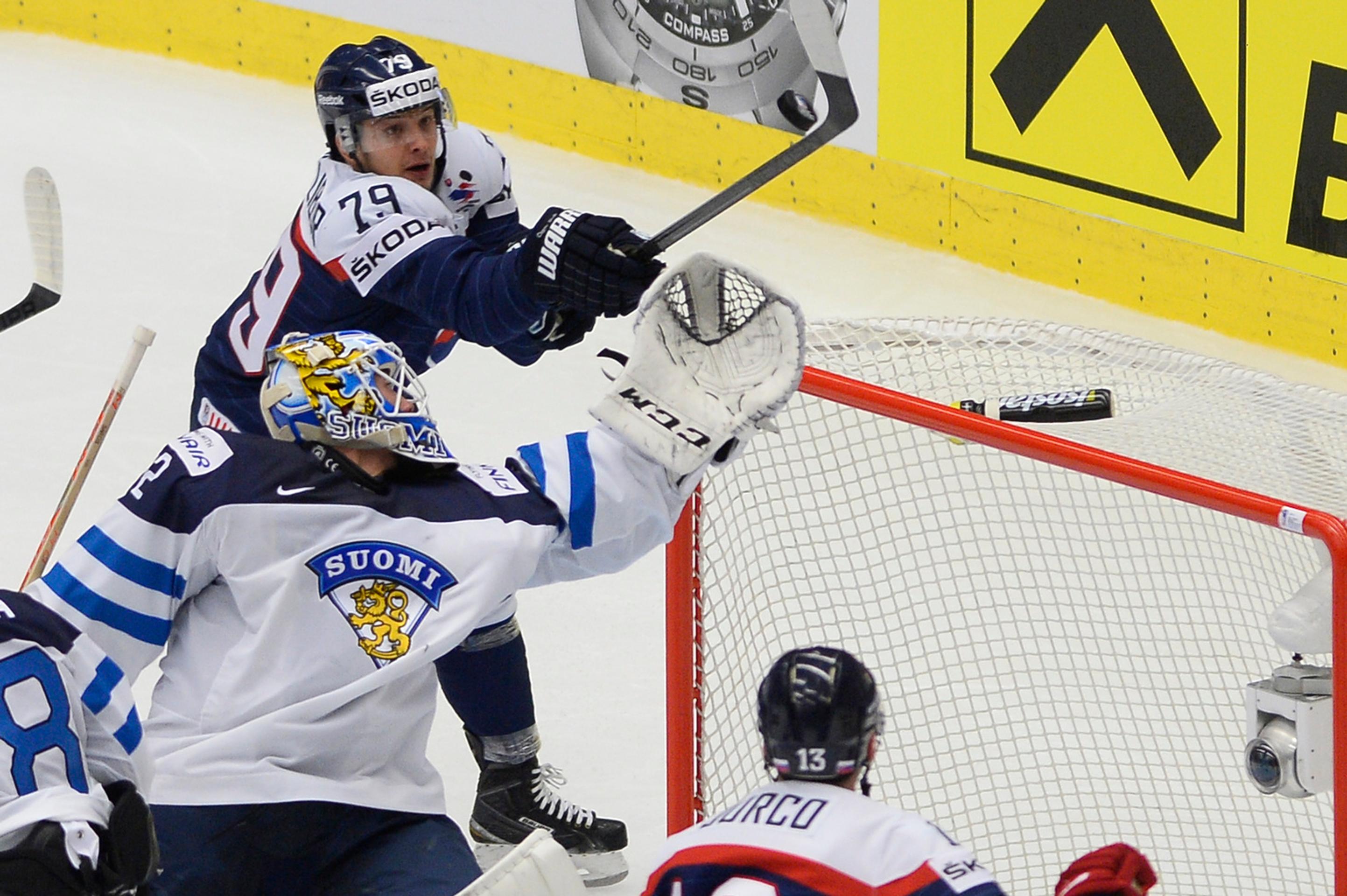 Vľavo slovenský hokejista Libor Hudáček usmerňuje puk za chrbát fínskeho brankára Jusseho Sarosa