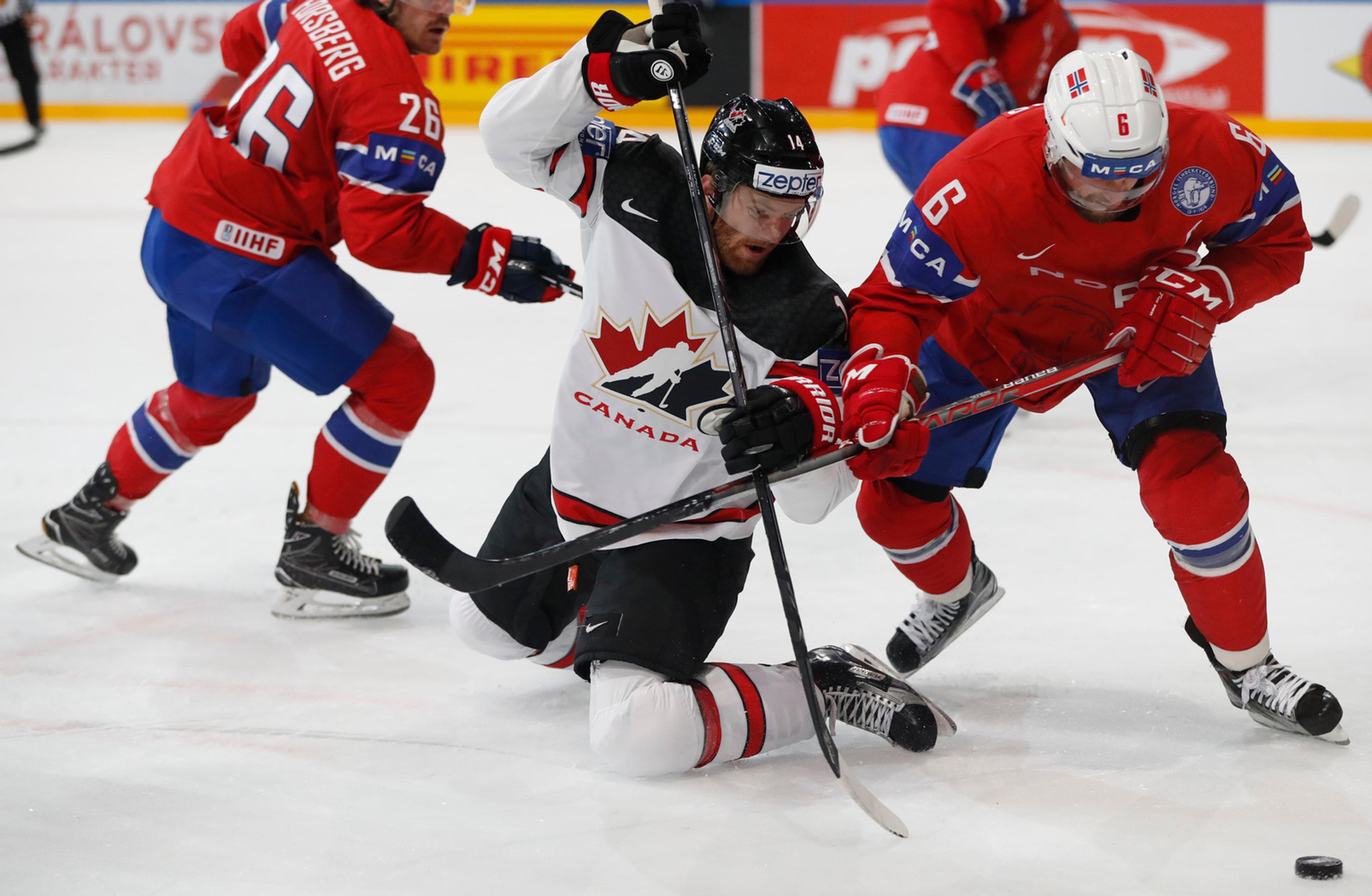 Jonas Holos (vpravo) z Nórska v súboji o puk s Kanaďanom Seanom Couturierom v zápase MS 2017.