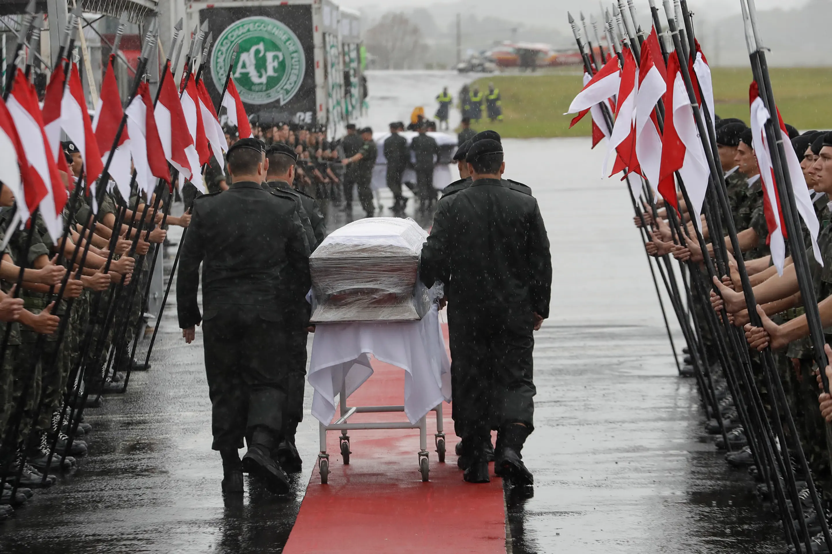 Vojaci kráčajú s rakvami tiel leteckej katastrofy v kolumbijskom Medellíne.