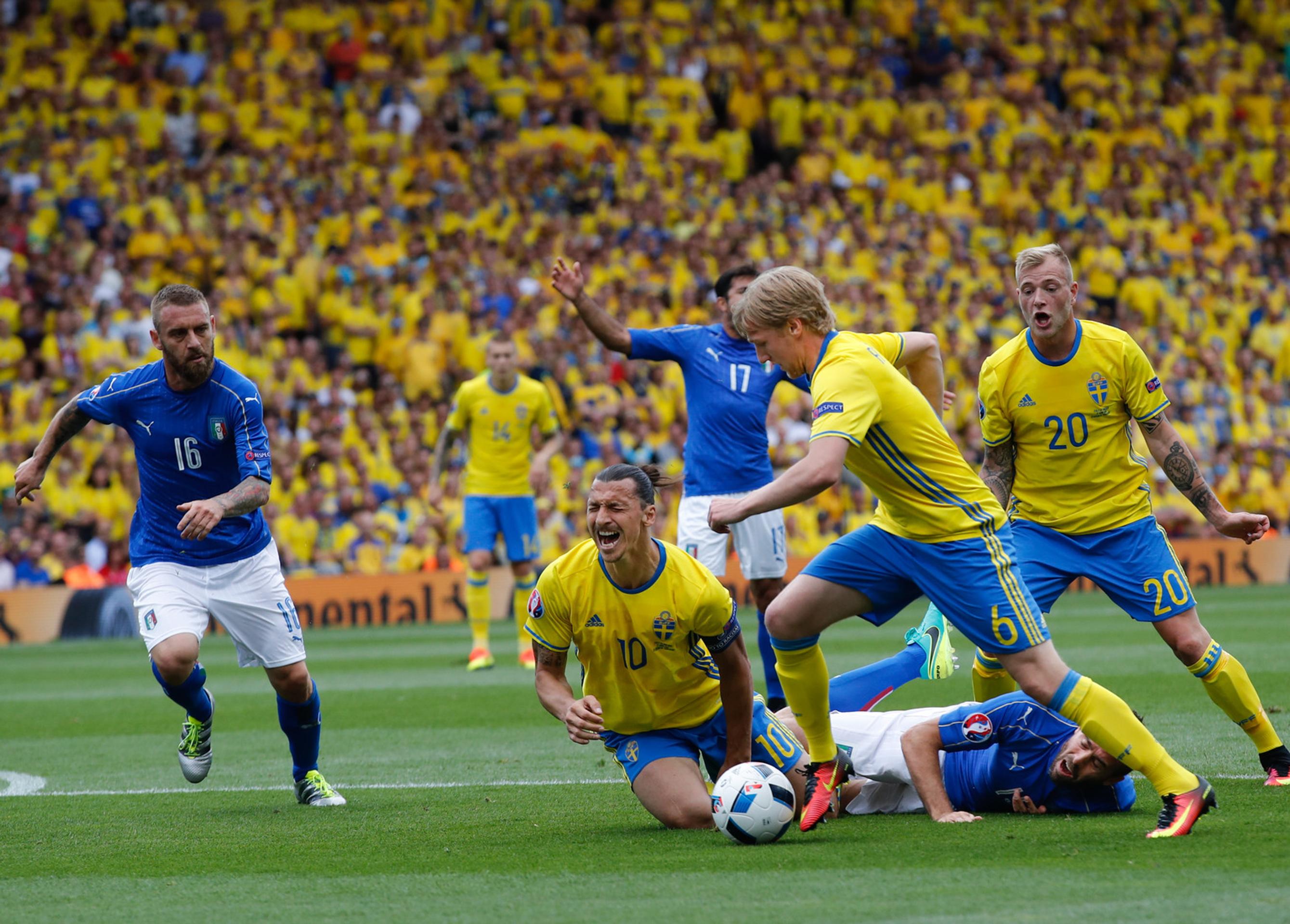 Švédska ikona hráč Zlatan Ibrahimovič padá po kolízii s Talianom Andreou Barzaglim, loptu berie Emil Forsberg.