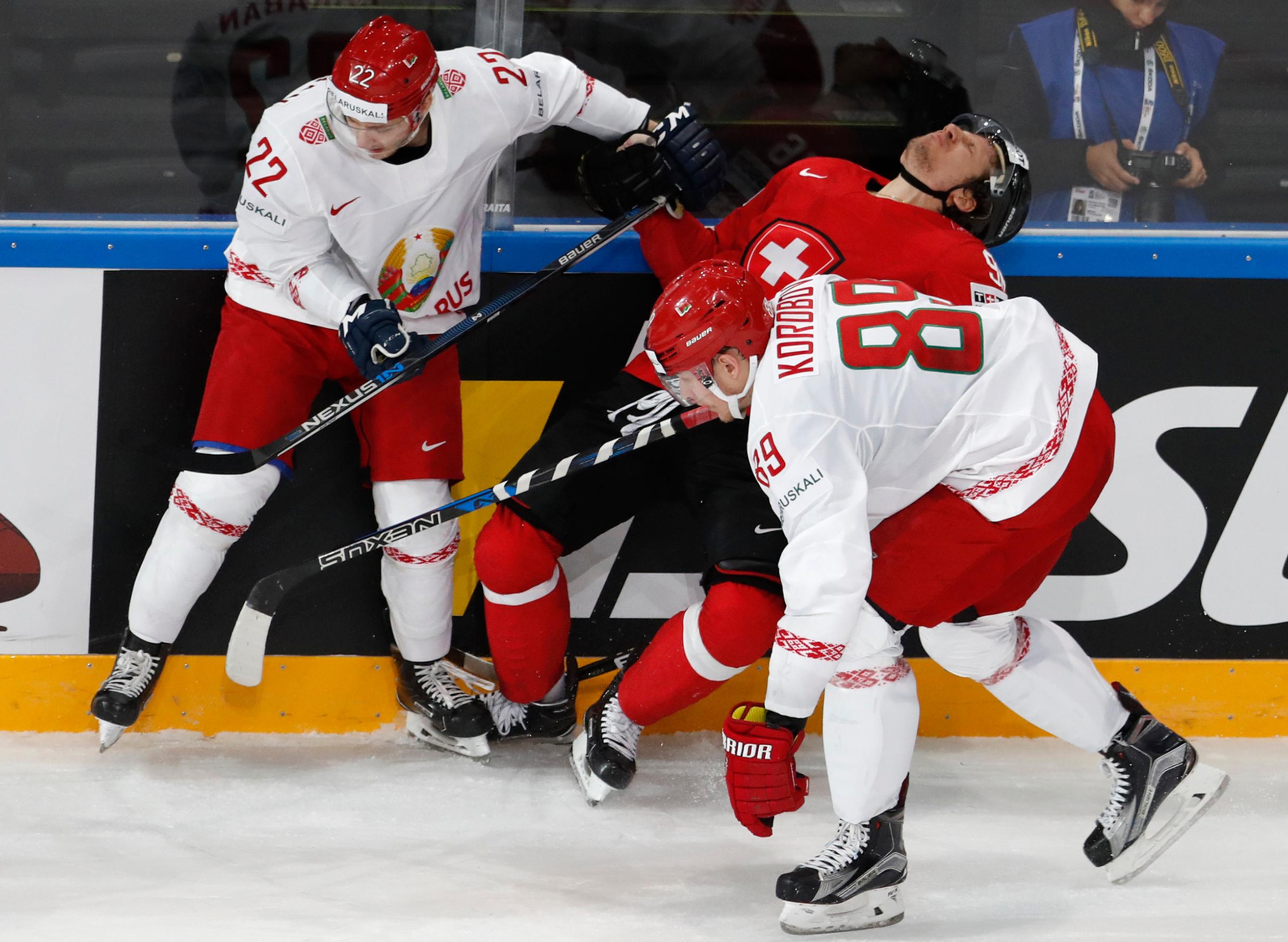 Bielorusi Danila Karaban (vľavo) a Dmitri Korobov atakujú Švajčiara Damiena Brunnera (v strede) v dueli MS 2017.