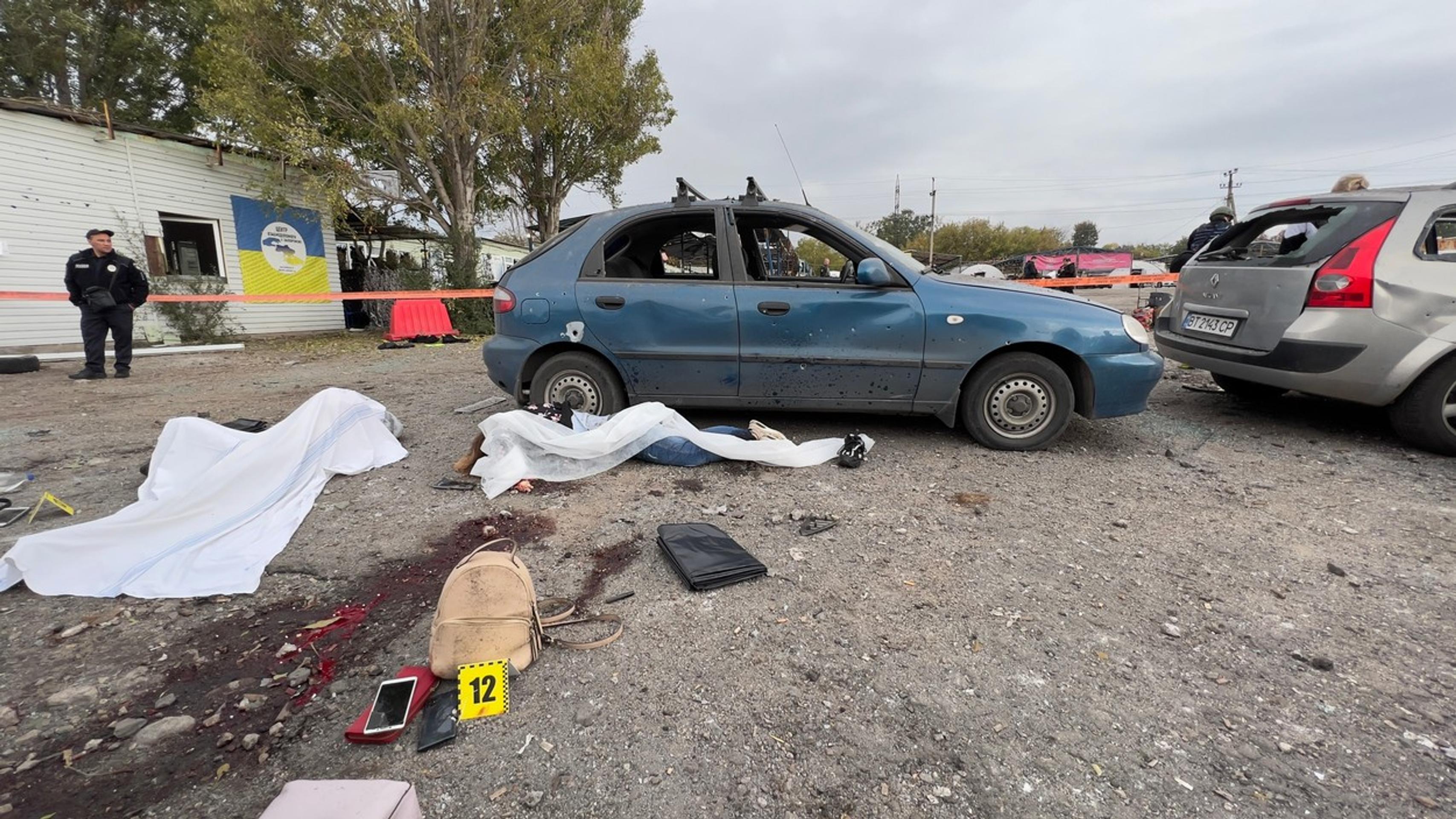 Následky raketového útoku na konvoj civilistov.