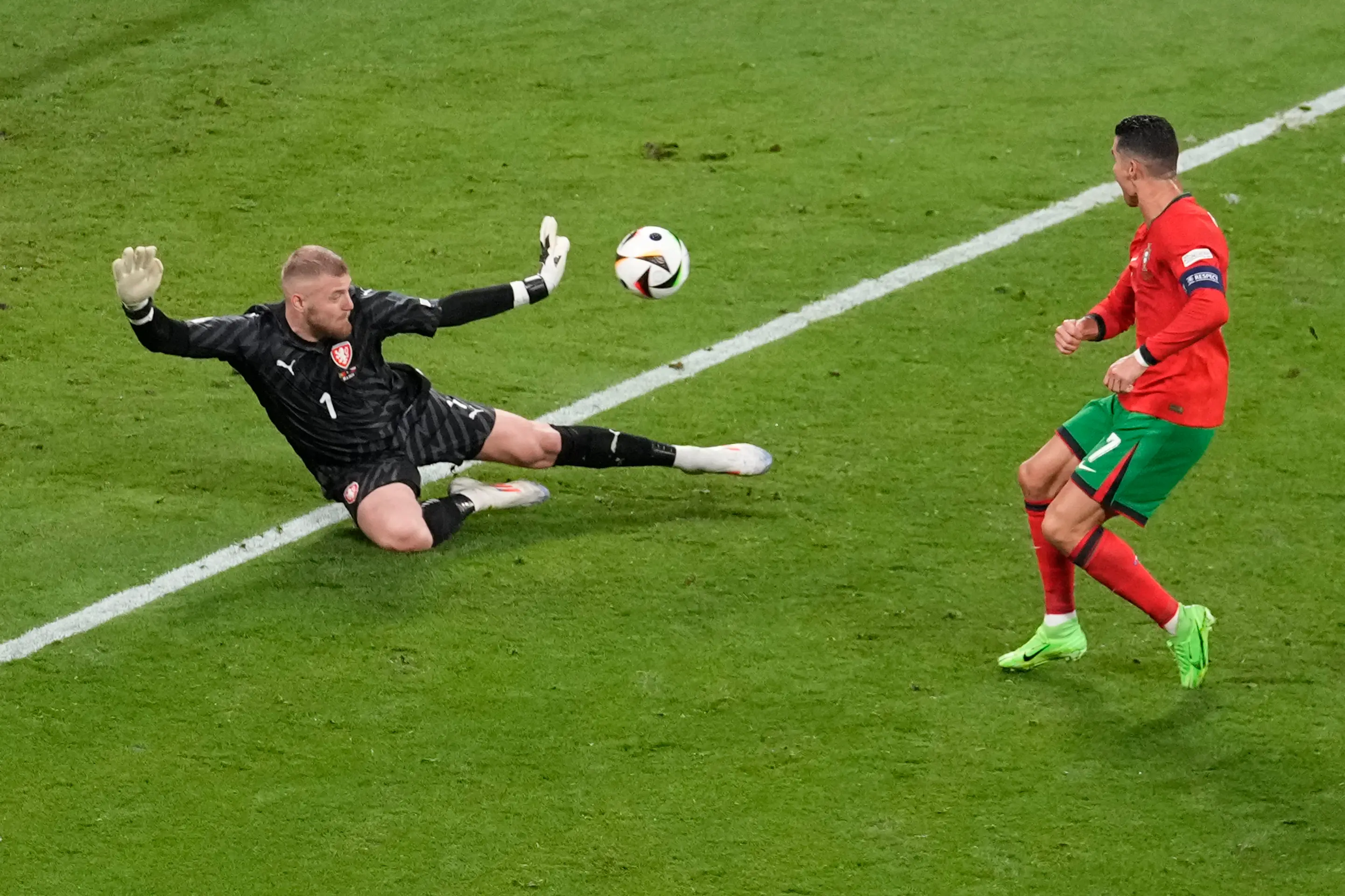Český brankár Jindřich Staněk (vľavo) zastavuje strelu Portugalca Cristiana Ronalda.