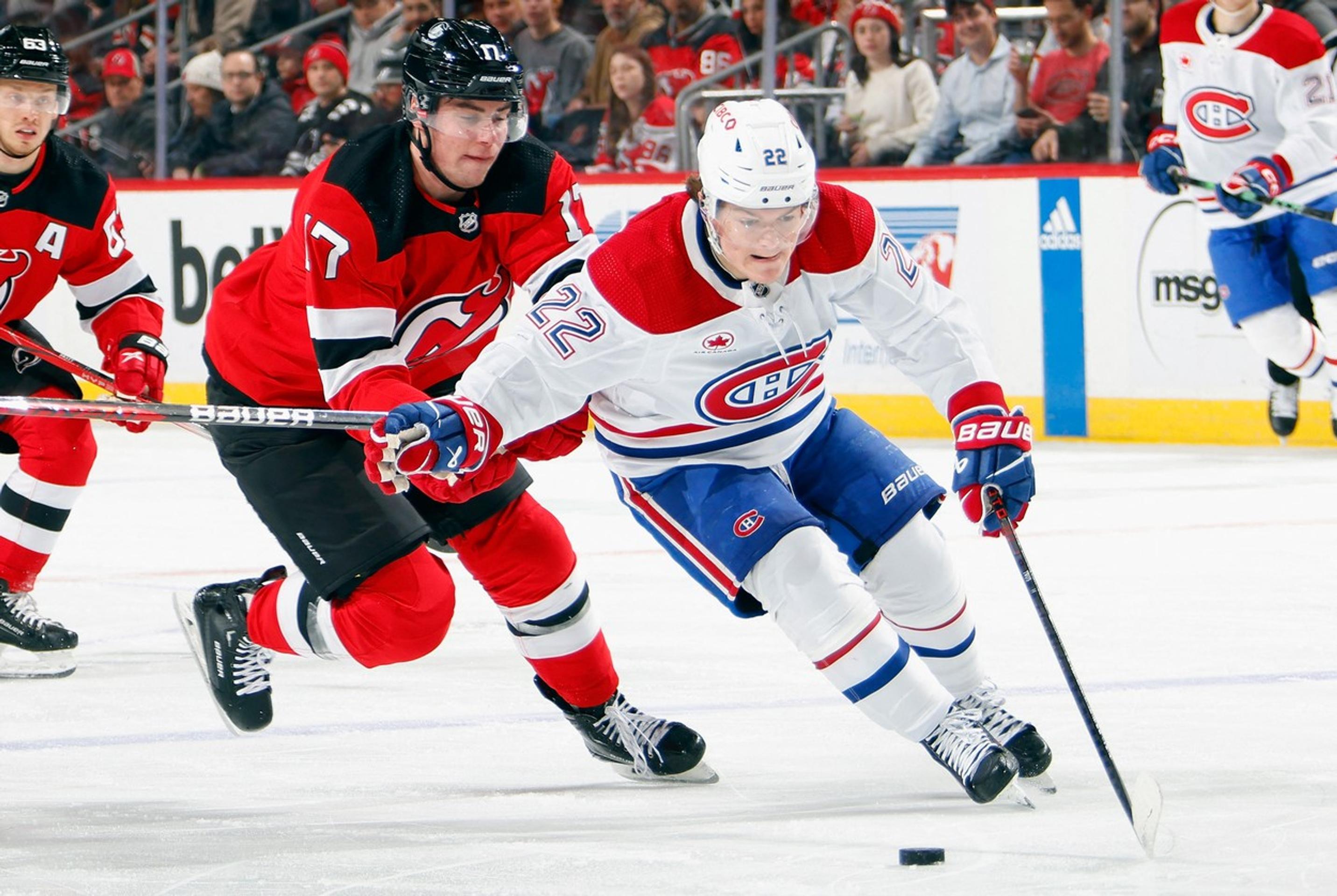 Šimon Nemec (v červenom) z New Jersey a Cole Caufield z Montrealu v súboji o puk.