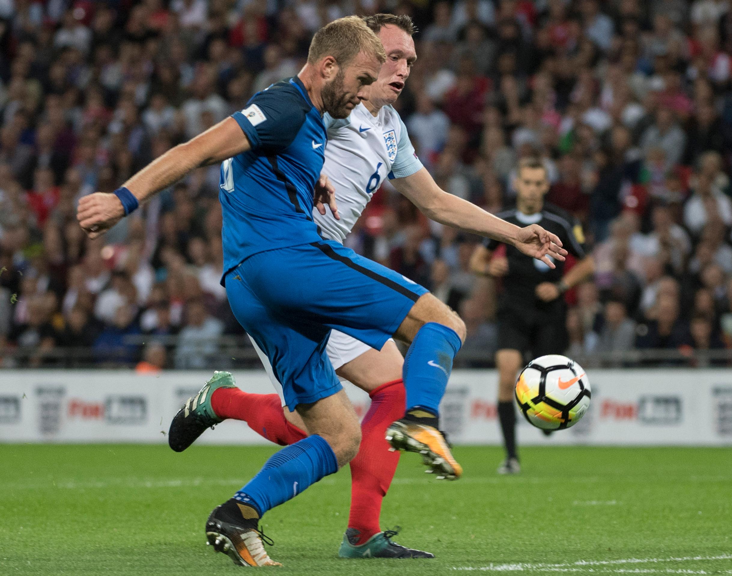 Adam Nemec sa snaž prepáliť loptu cez Phila Jonesa v zápase kvalifikácie MS proti Anglicku.