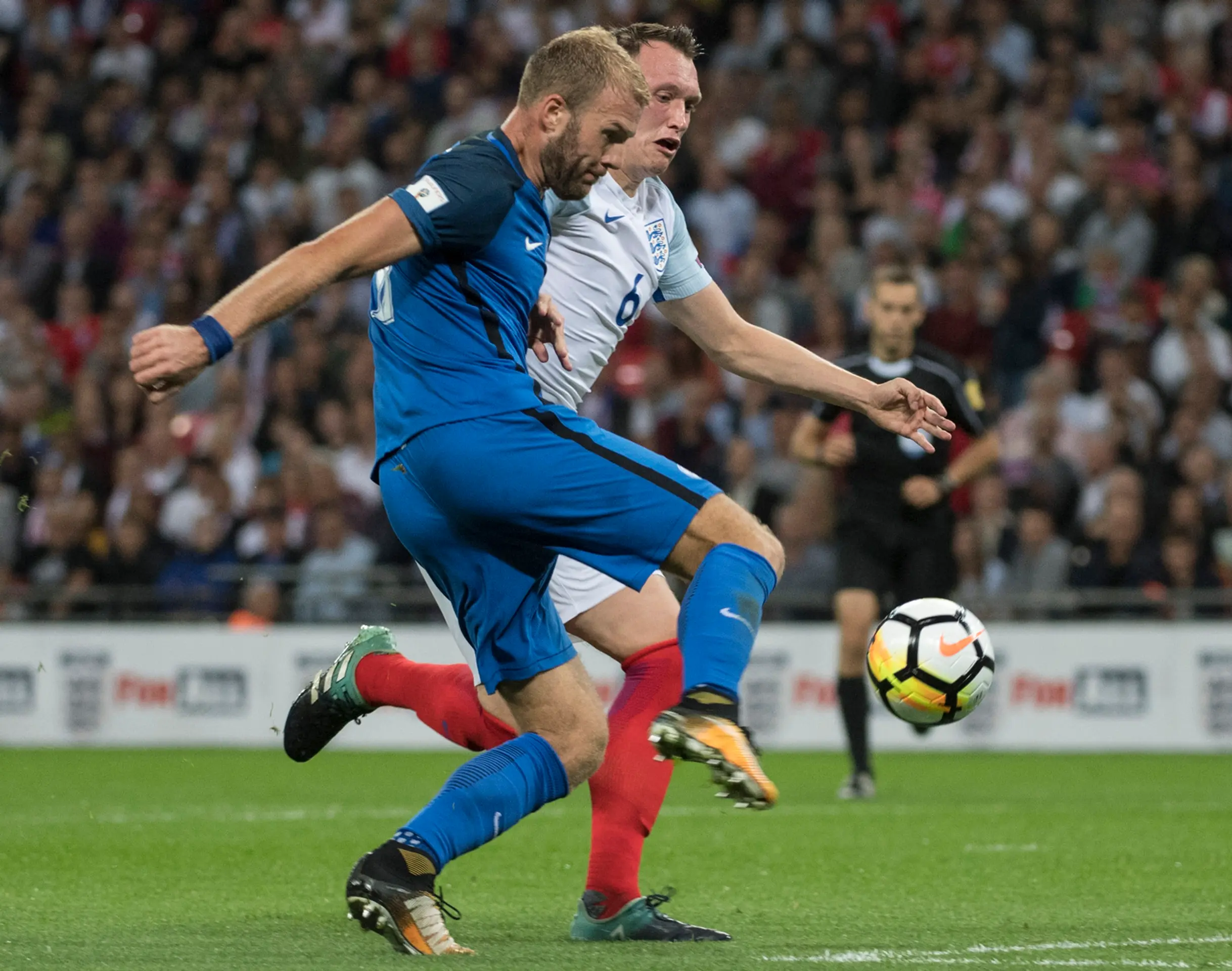Adam Nemec sa snaž prepáliť loptu cez Phila Jonesa v zápase kvalifikácie MS proti Anglicku.