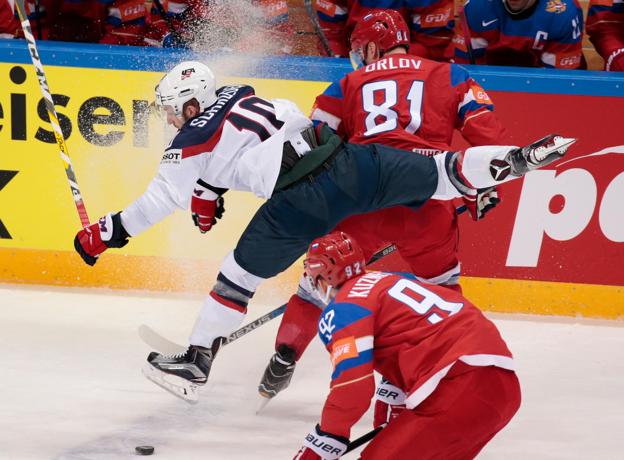 Dmitrij Orlov (hore) tvrdo zastavuje amerického hráča Jordana Schroedera (vľavo) v zápase na MS v Rusku