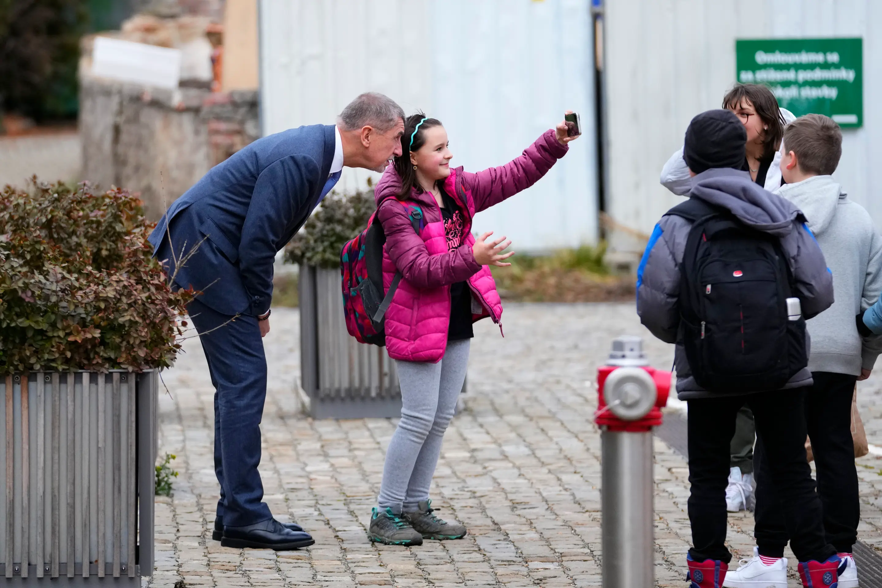 Bývalý premiér Českej republiky a kandidát na prezidenta Andrej Babiš sa fotí s malým dievčatkom pred volebnou miestnosťou v 1. kole prezidentských volieb.