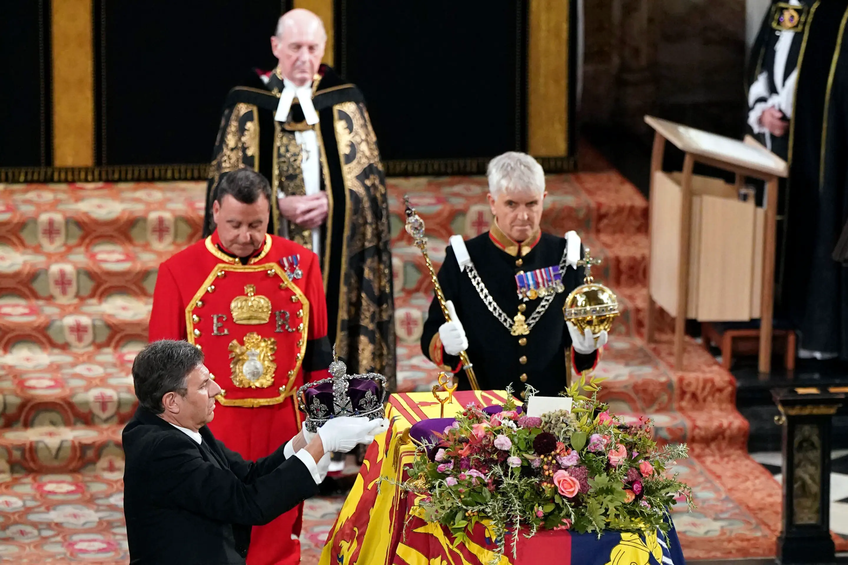 Kráľovský klenotník berie kráľovskú korunu z rakvy s pozostatkami zosnulej britskej kráľovnej Alžbety II.