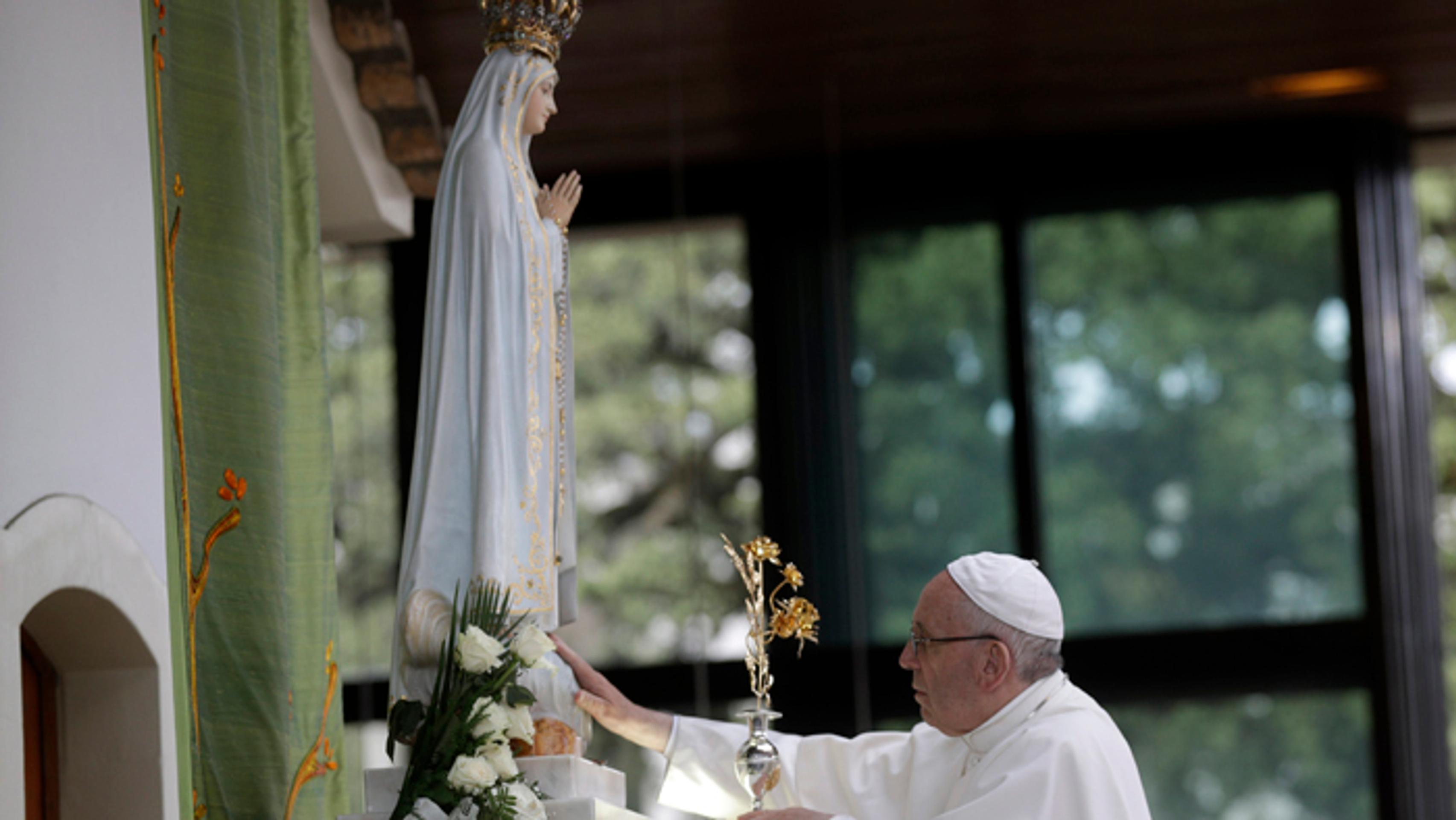 Pápež František sa dotýka sochy Panny Márie v svätyni na mieste jej zjavení v portugalskej Fátime.