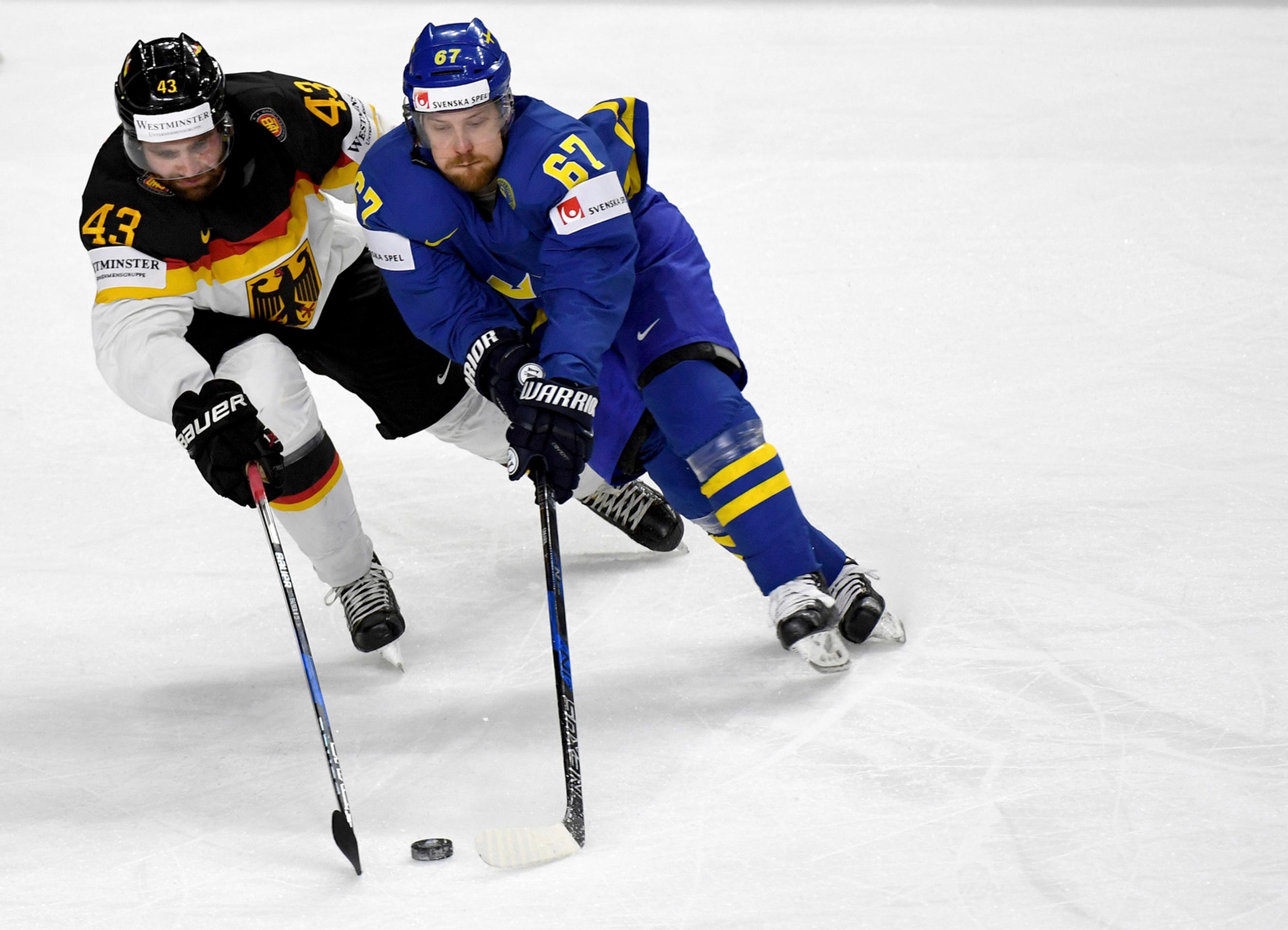 Nemec Gerrit Fauser a Švéd Linus Omark v súboji o puk.