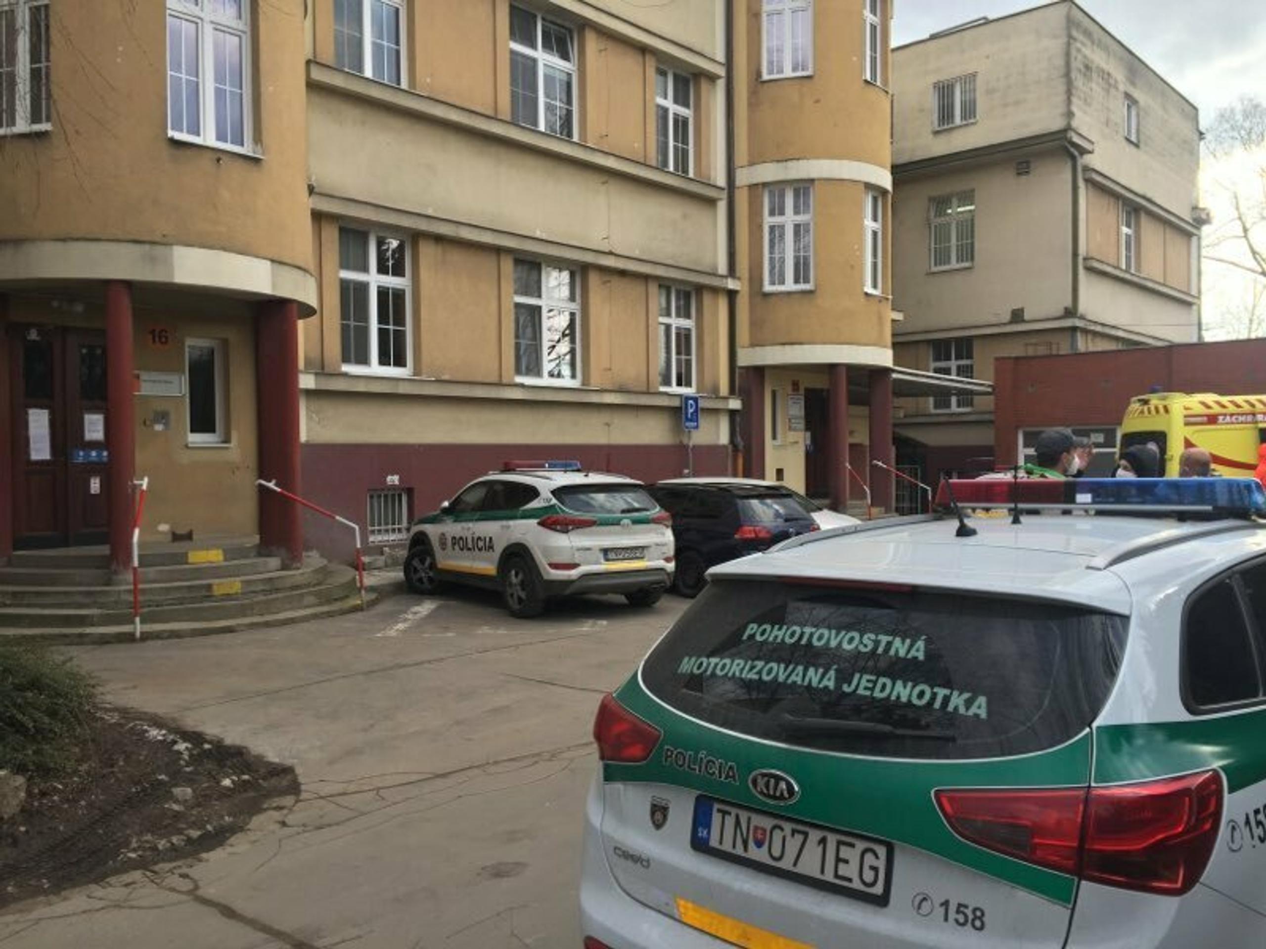 Policajné autá a sanitka pred trenčianskou nemocnicou, kde je hospitalizovaná Monika Jankovská.