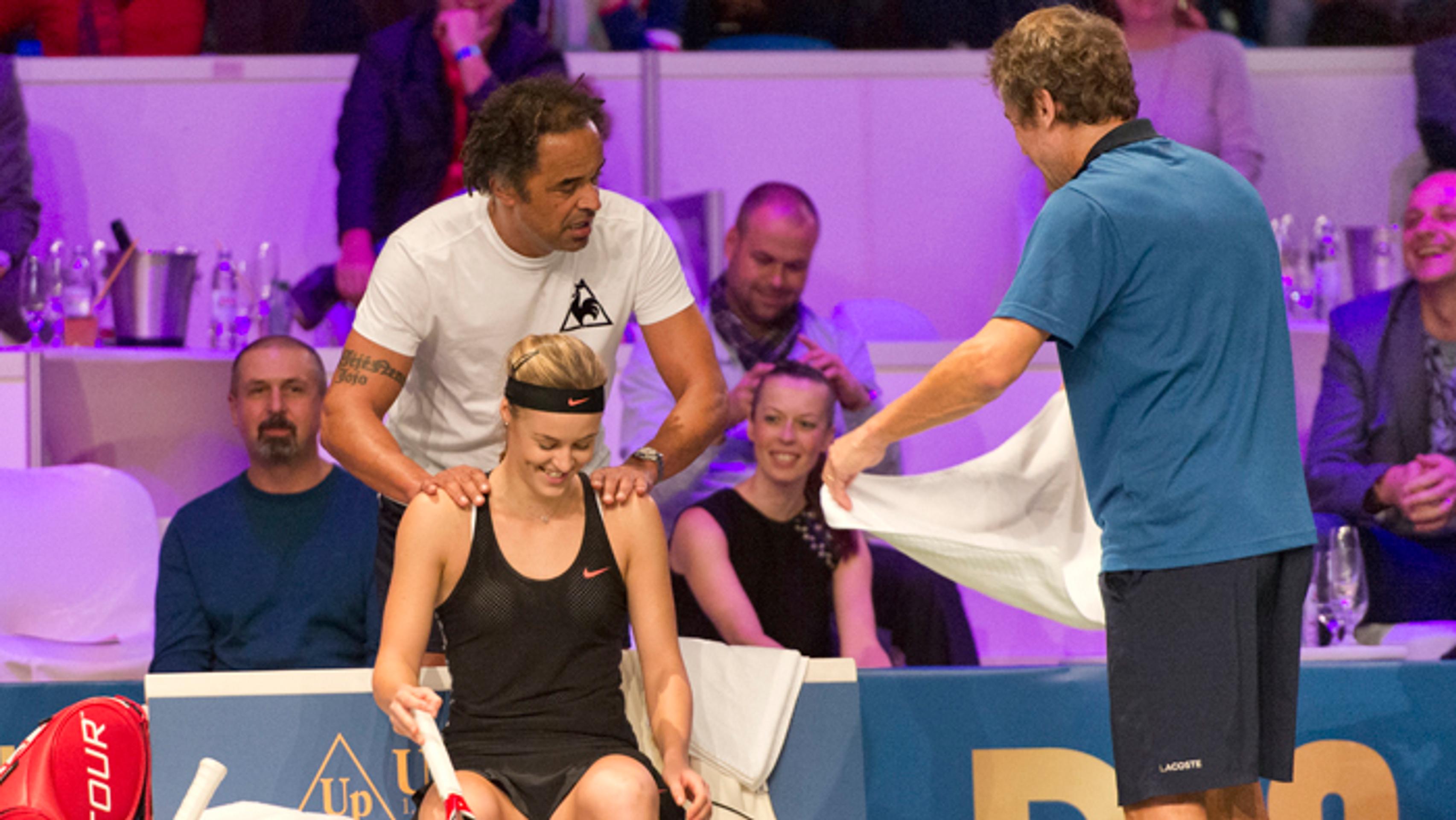 Yannick Noah masíruje Annu Karolínu Schmiedlovú a uterákom ju ovieva Mats Wilander počas mixu na exhibícii Tennis Champions.