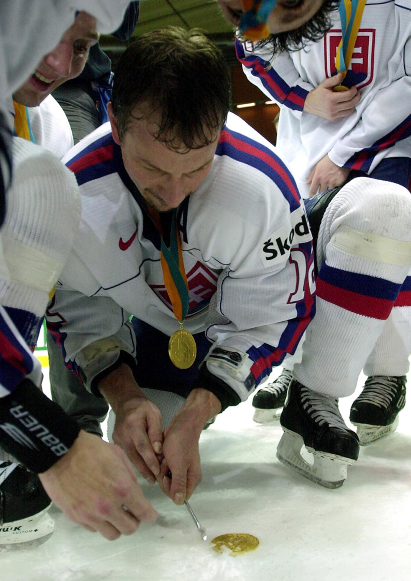 Peter Bondra vyberá z ľadu zlatú medailu spoluhráčovi Petrovi Smrekovi na MS v Göteborgu.
