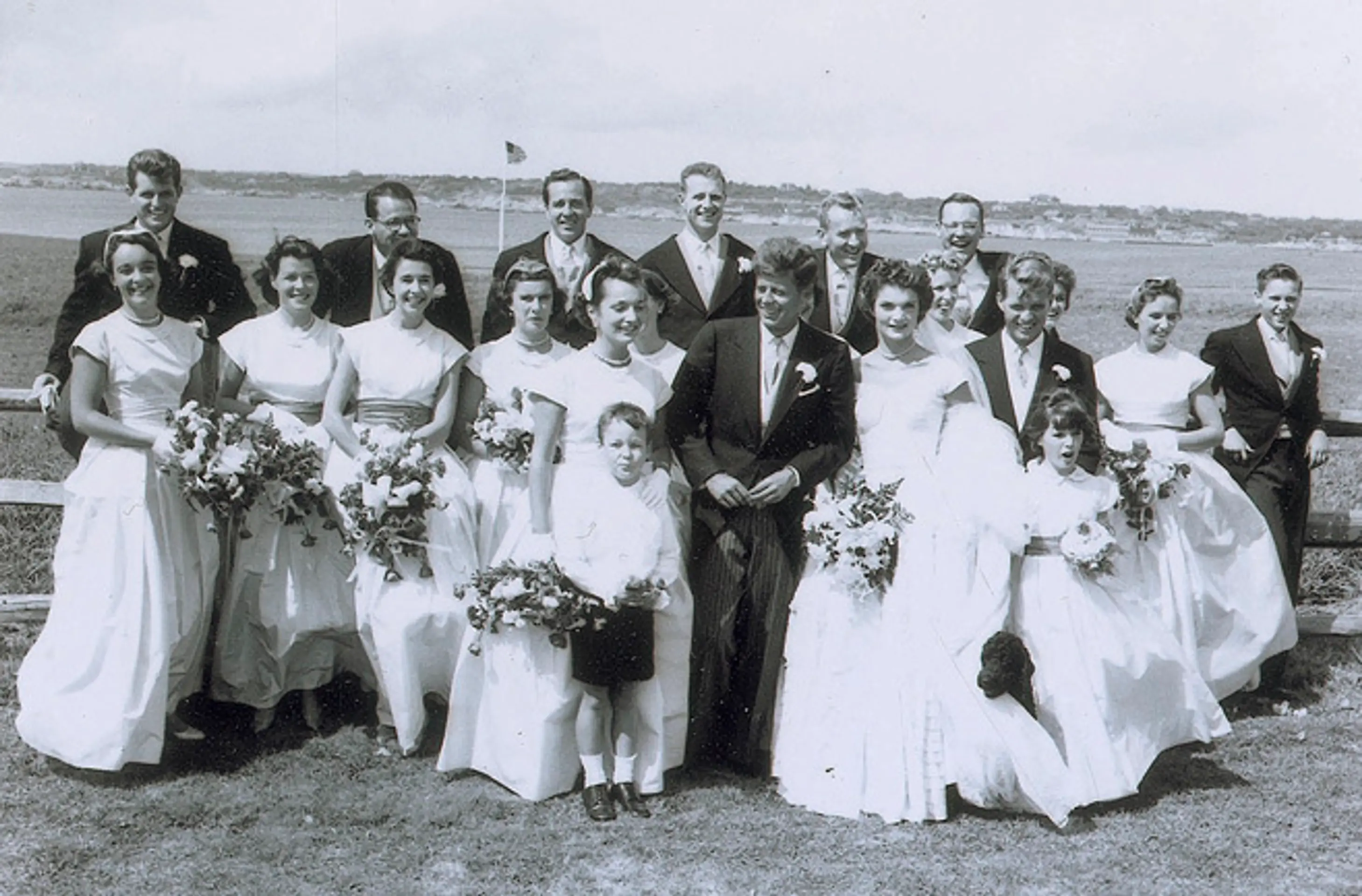 John F. Kennedy a manželka Jacqueline pózujú so sobášnymi hosťami v americkom Newporte.