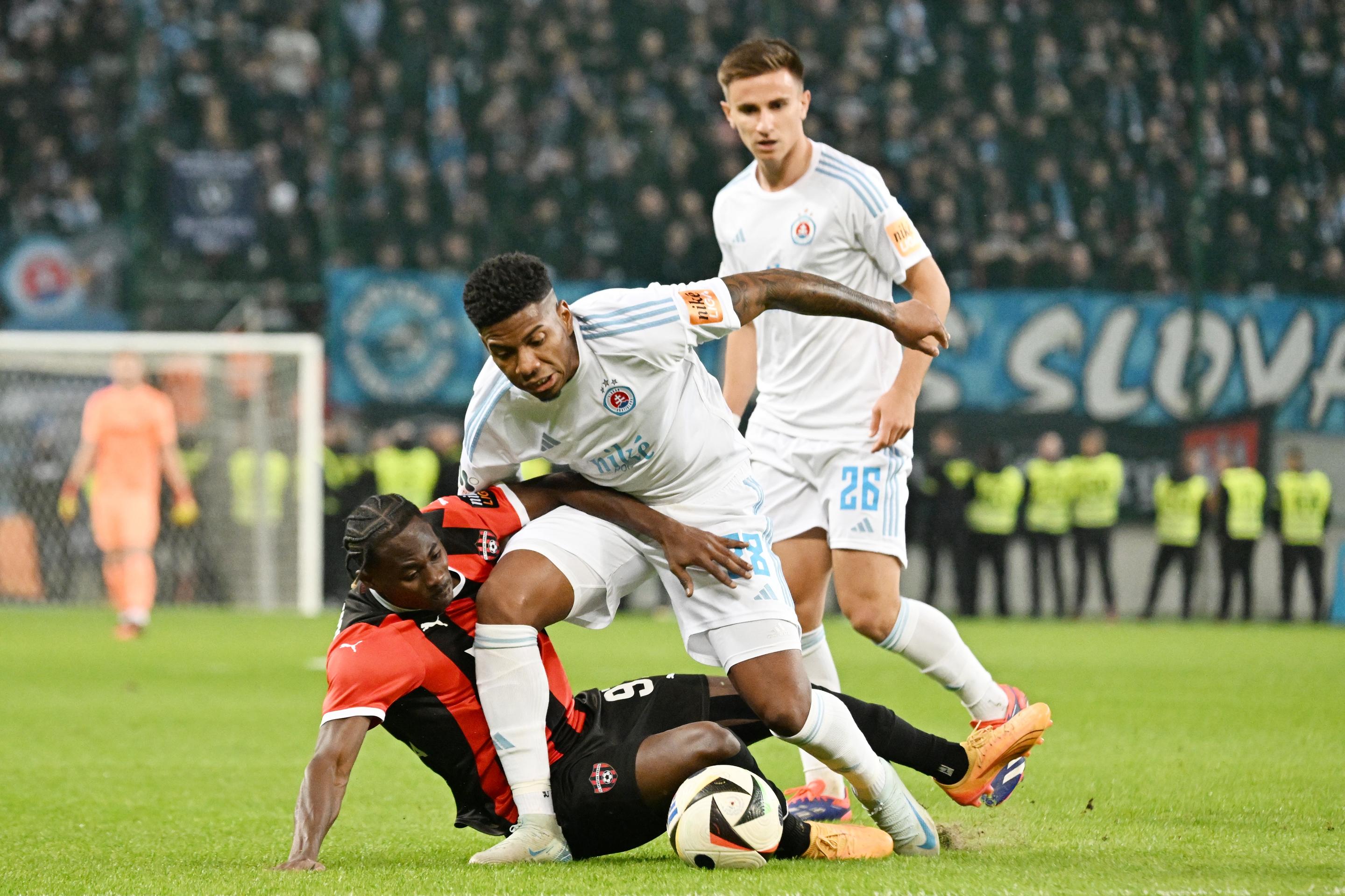 Zľava hráč Spartaka Kelvin Ofori a hráči Slovana Sharani Zuberu a Artur Gajdoš v 11. kole Niké ligy.