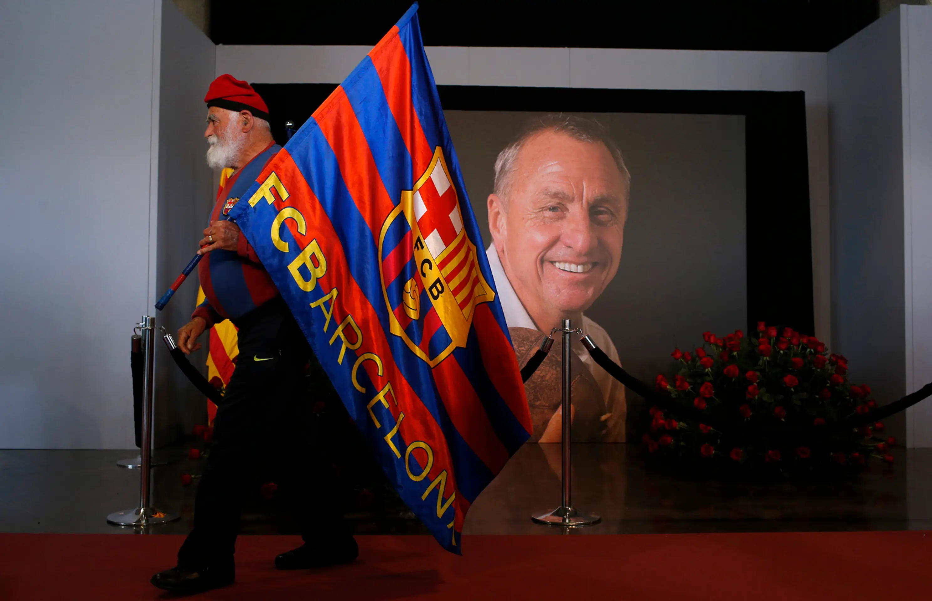 Fanúšik drží vlajku na počesť legendárneho holandského futbalistu, kapitána a trénera FC Barcelona Johana Cruyffa. 29. marca