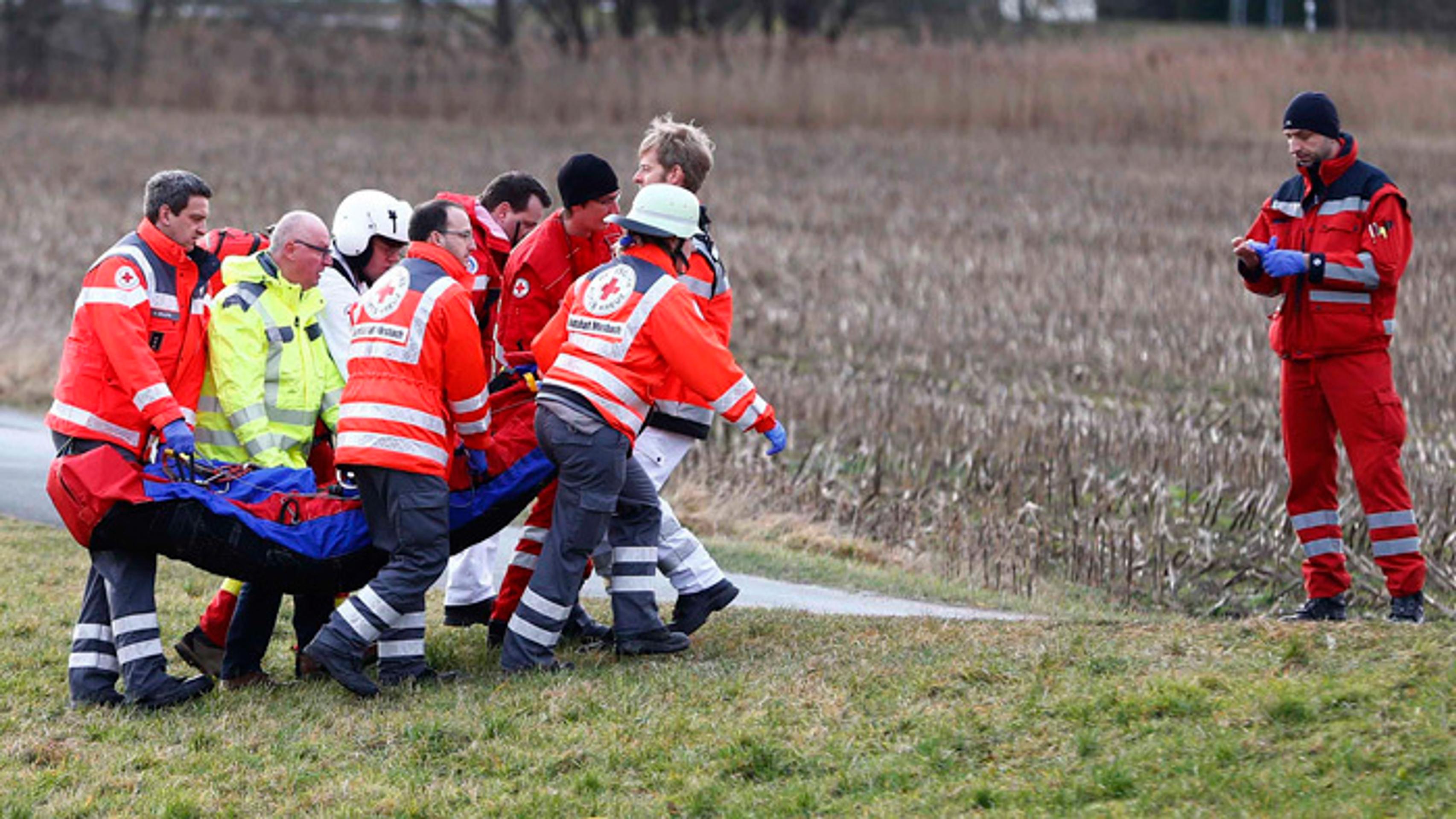 Záchranári odvážajú zraneného pasažiera na mieste zrážky dvoch vlakov v nemeckom Bad Aiblingu.