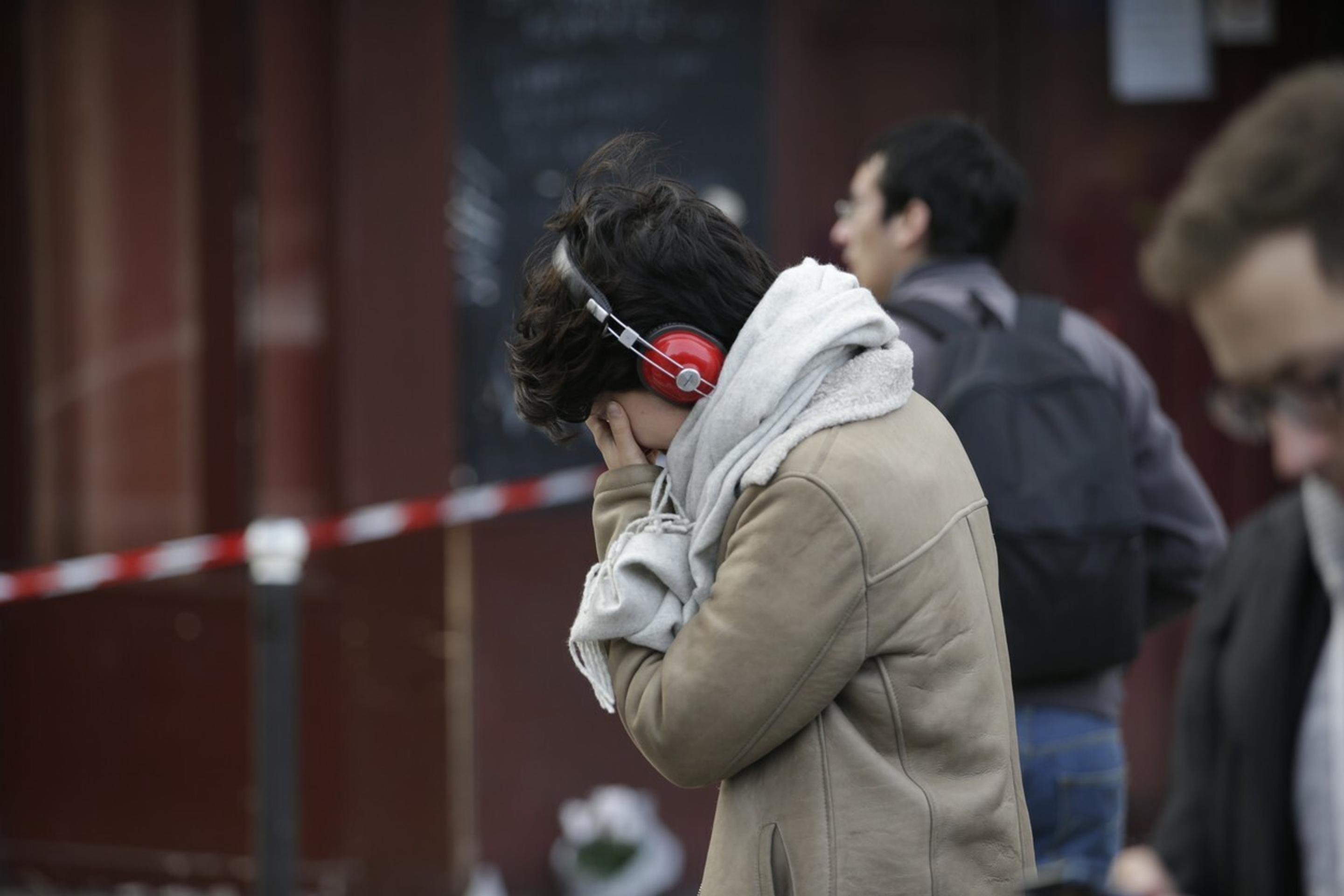 Plačúca žena pred barom Carillon, kde sa odohral jeden z útokov.