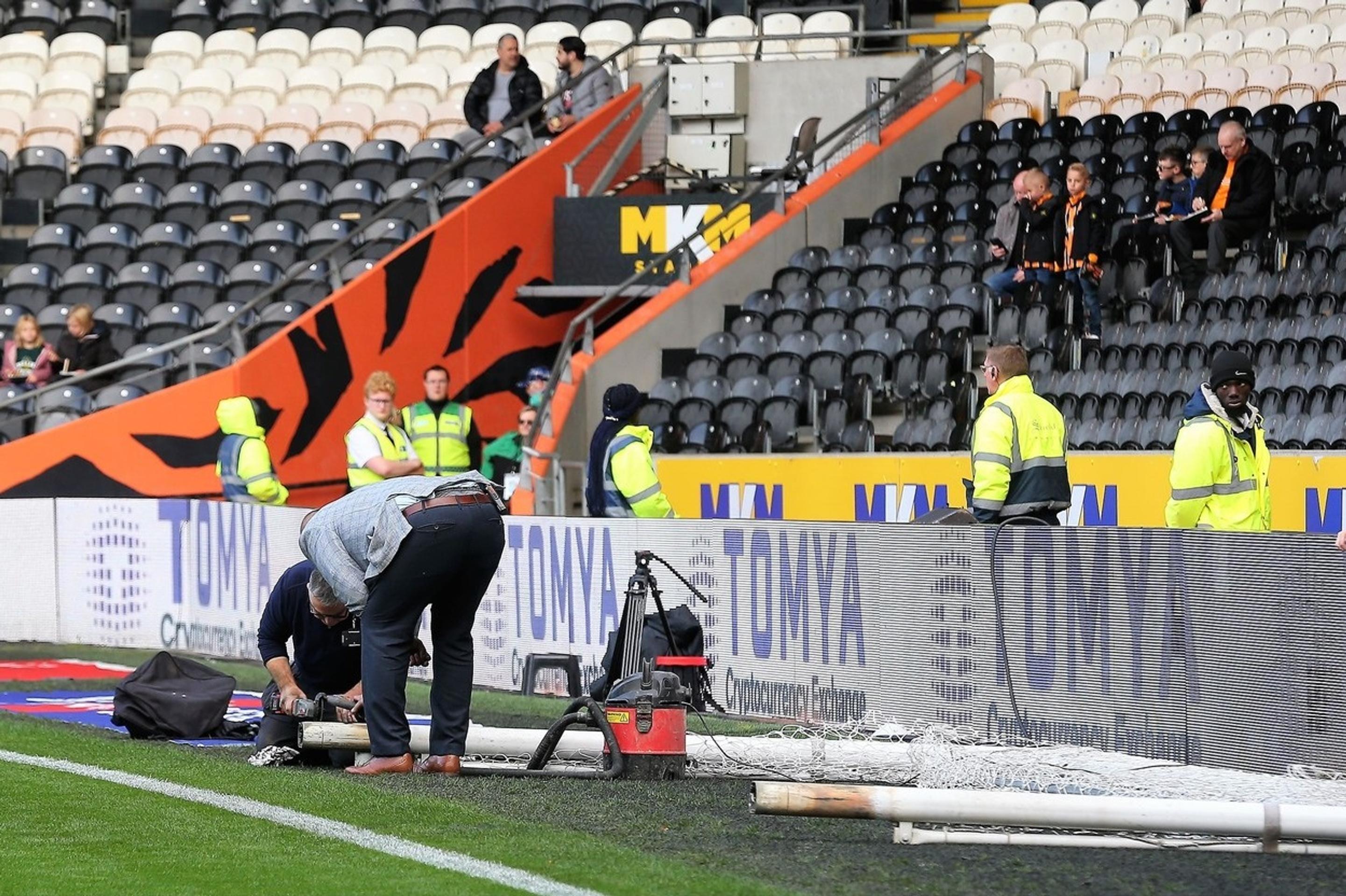 Robotníci upravujú bránky pred zápasom Hull - Birmingham.