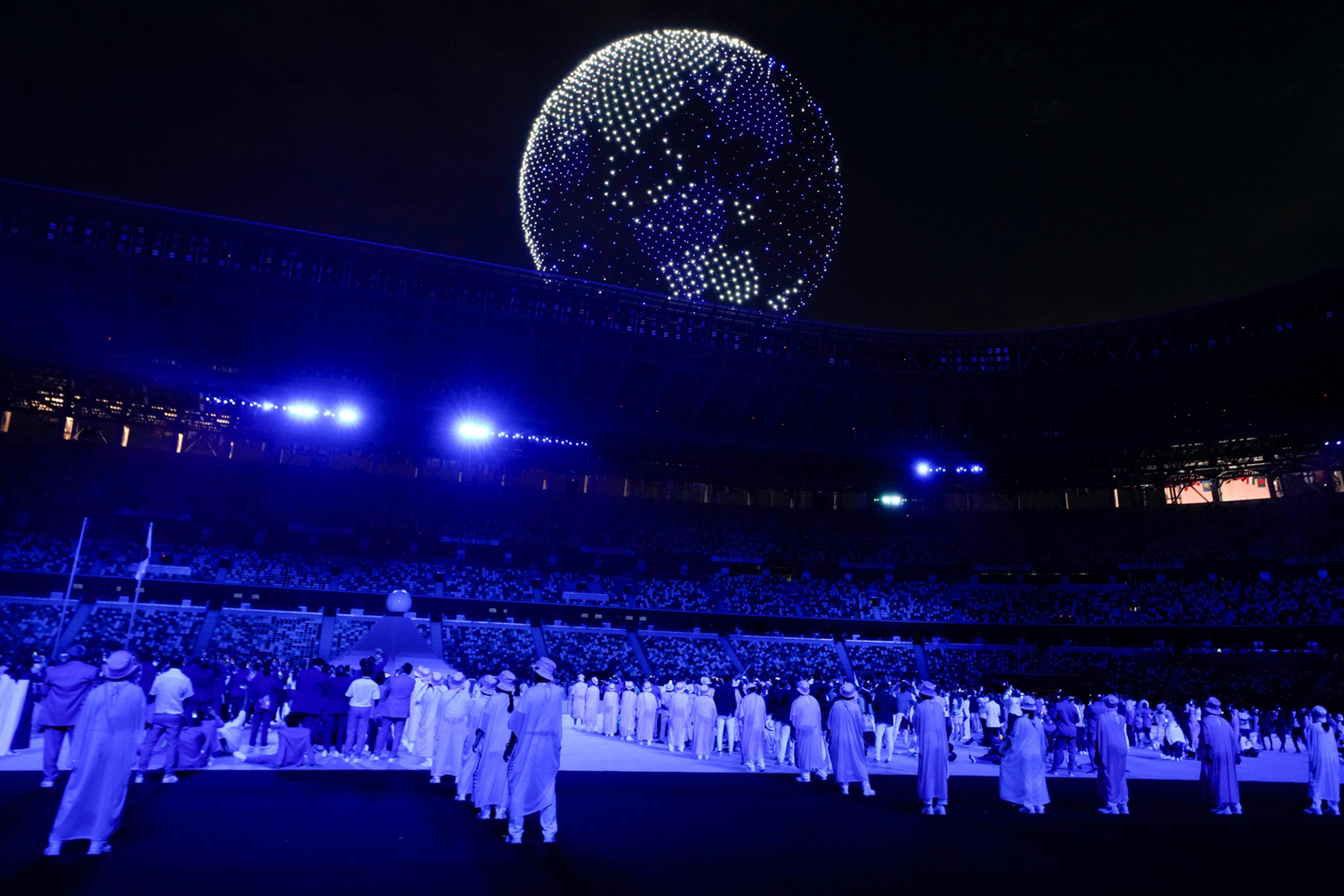 Na snímke drony v tvare zemegule letia nad Olympijským štadiónom počas otváracieho ceremoniálu LOH v Tokiu.