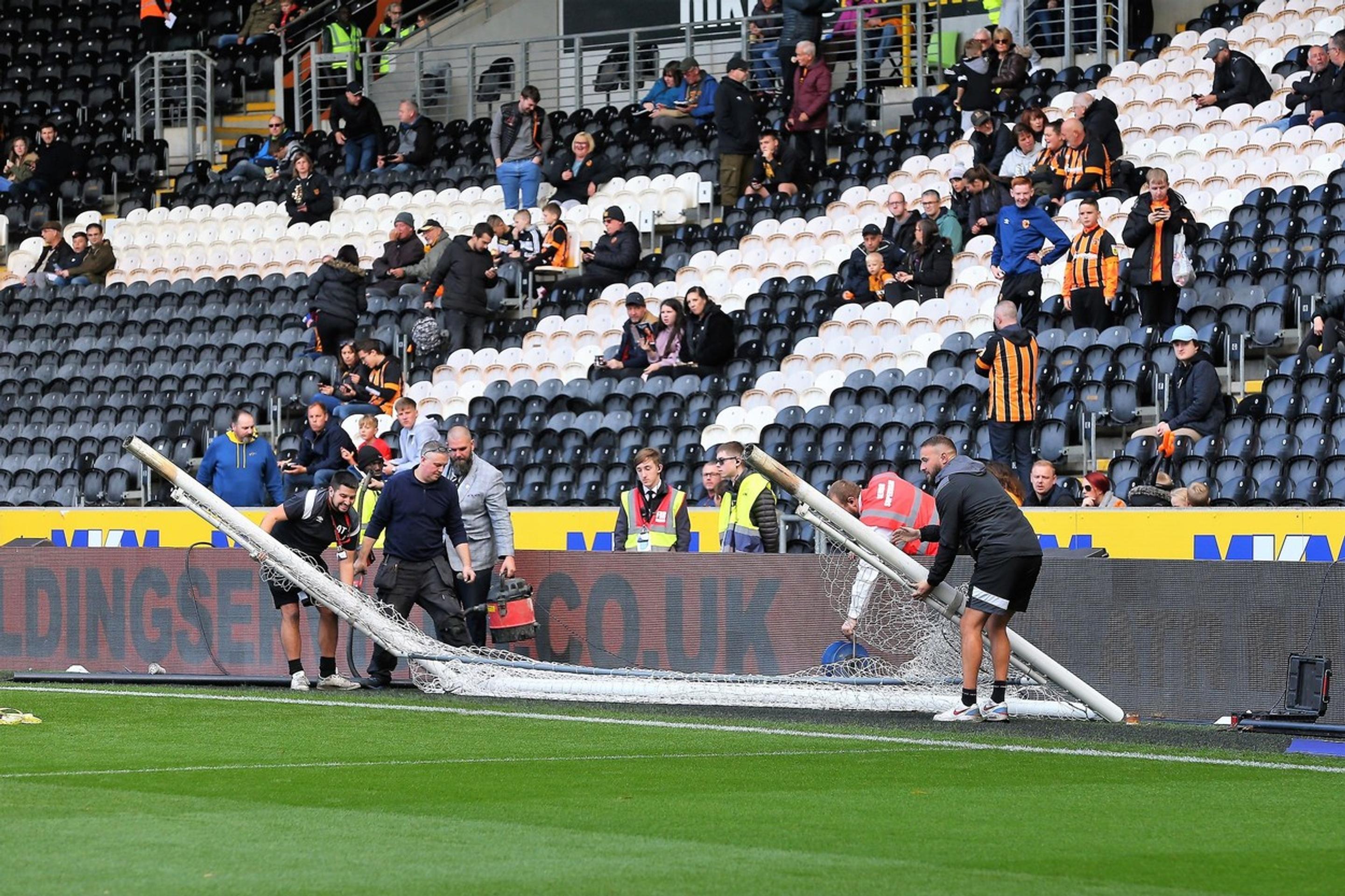 Robotníci upravujú bránky pred zápasom Hull - Birmingham.