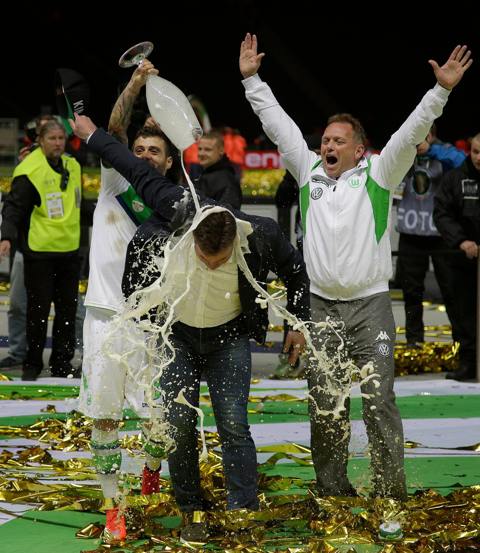 Portugalčan Vieirinha leje pivo na trénera Wolfsburgu Dietera heckinga po výhre vo finále Nemeckého pohára.