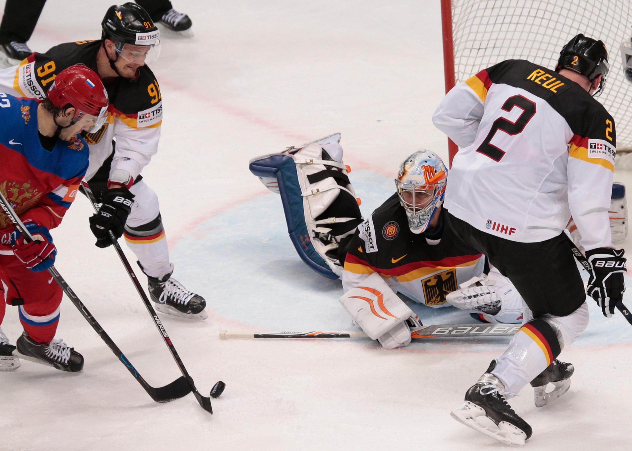 Rus Jevgenij Dadonov (vľavo) bojuje o puk s Nemcom Moritzom Müllerom (druhý zľava), brankárom Thomasom Greissom a Denisom Reulom