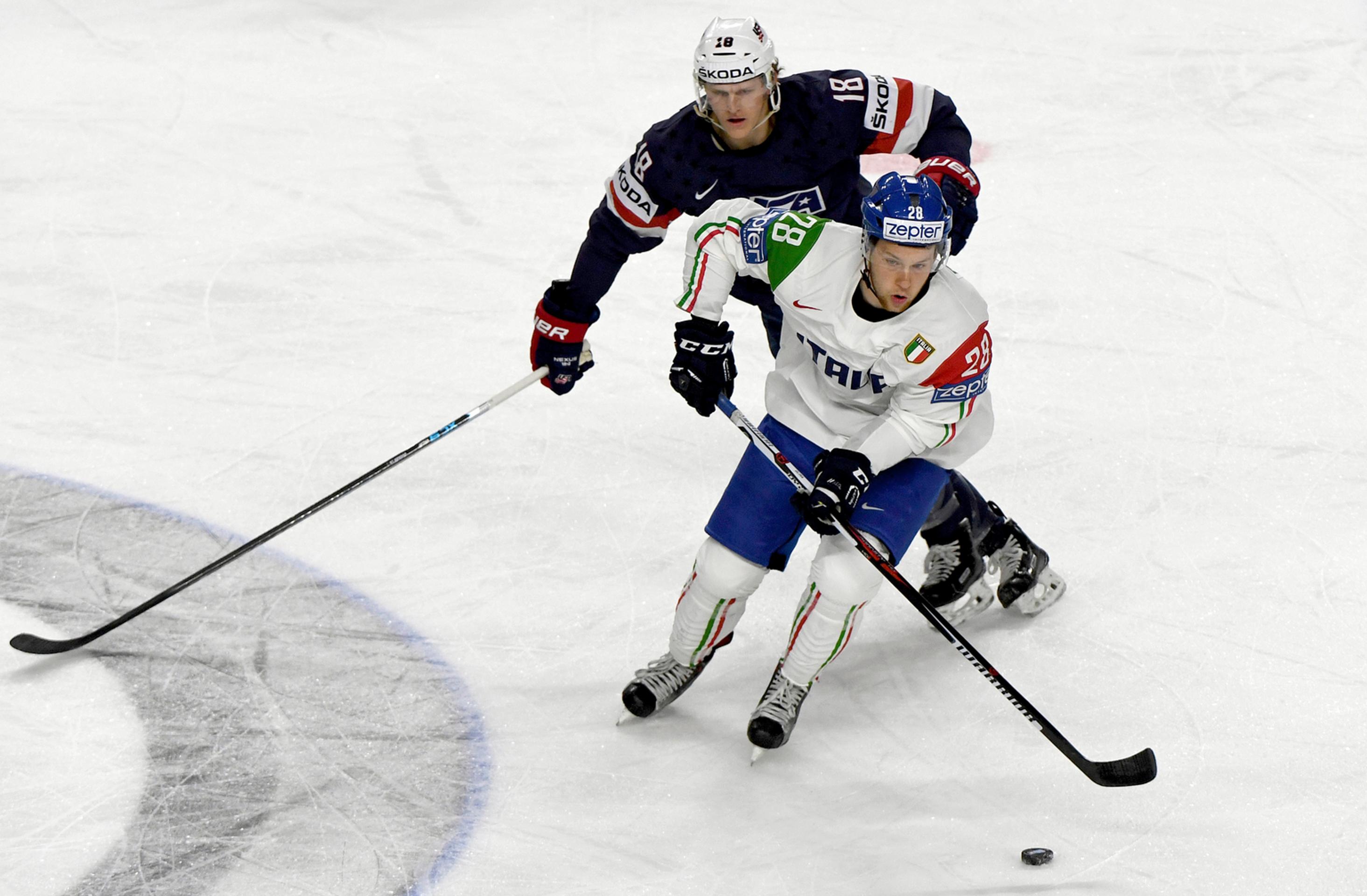 Američan Christian Dvorak (vzadu) naháňa v zápase MS 2017 Taliana Daniela Gliru.