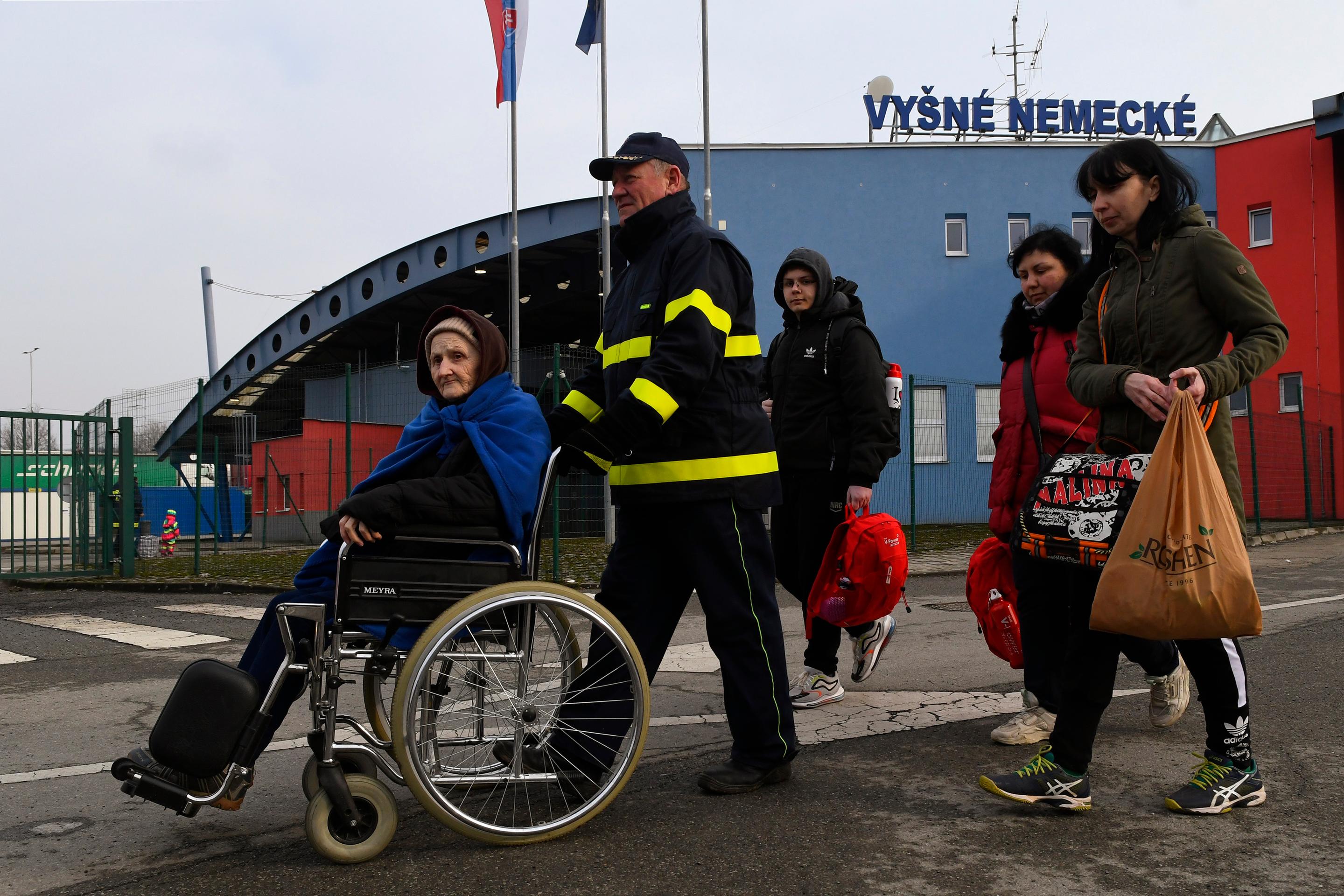 Snímka z príchodu ukrajinských utečencov na hraničnom priechode Vyšné Nemecké. Starým ľudom pomáhajú členovia Červeného kríža z Ukrajiny aj Slovenska.