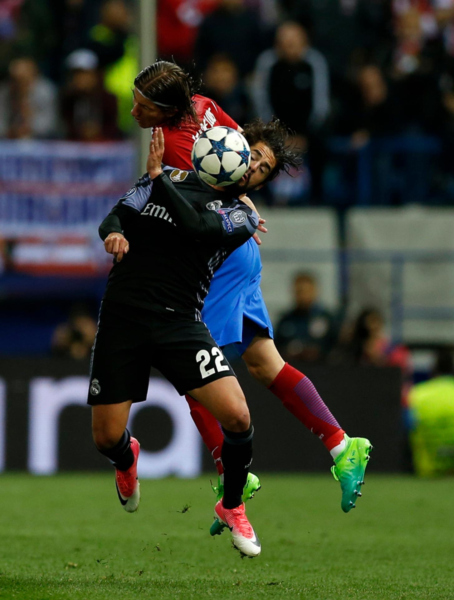 Vpravo hráč Atletico Filipe Luis v súboji s hráčom Realu Iscom.