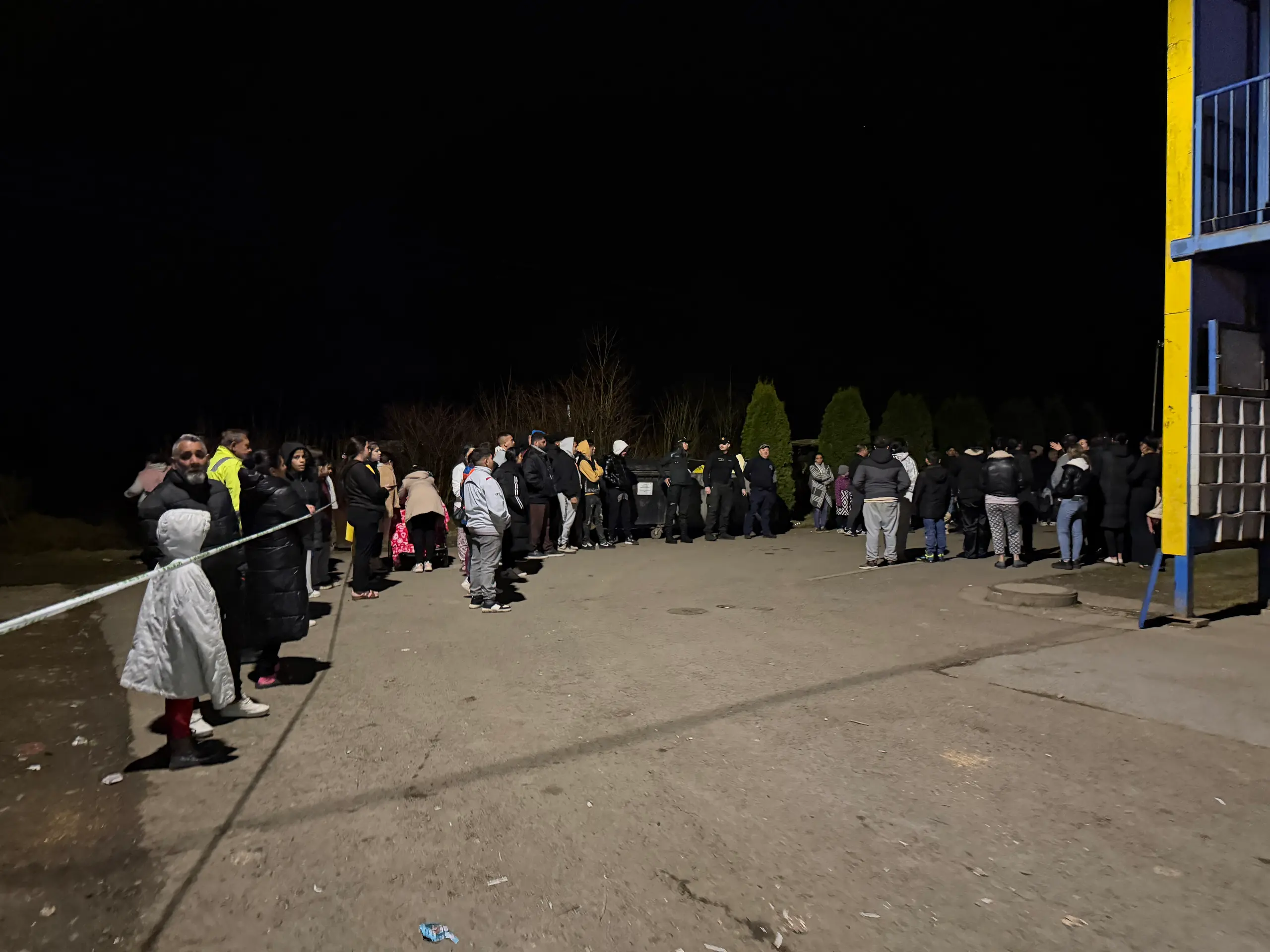 Na snímke obyvatelia bytovky stoja vonku, zatiaľčo hasiči aktuálne zasahujú pri požiari bytového domu na Festivalovej ulici vo Svidníku.