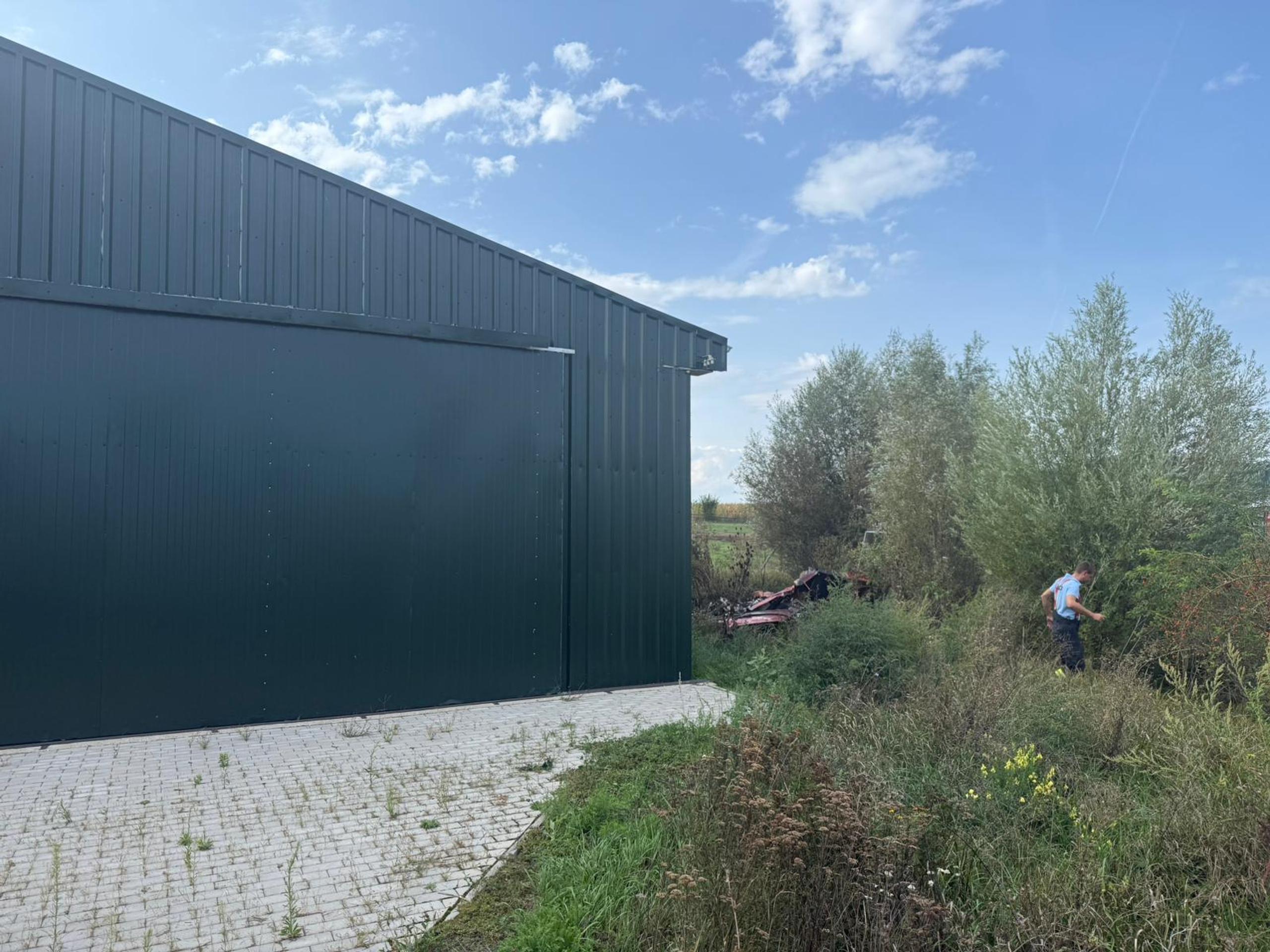 Lietadlo spadlo blízko haly.