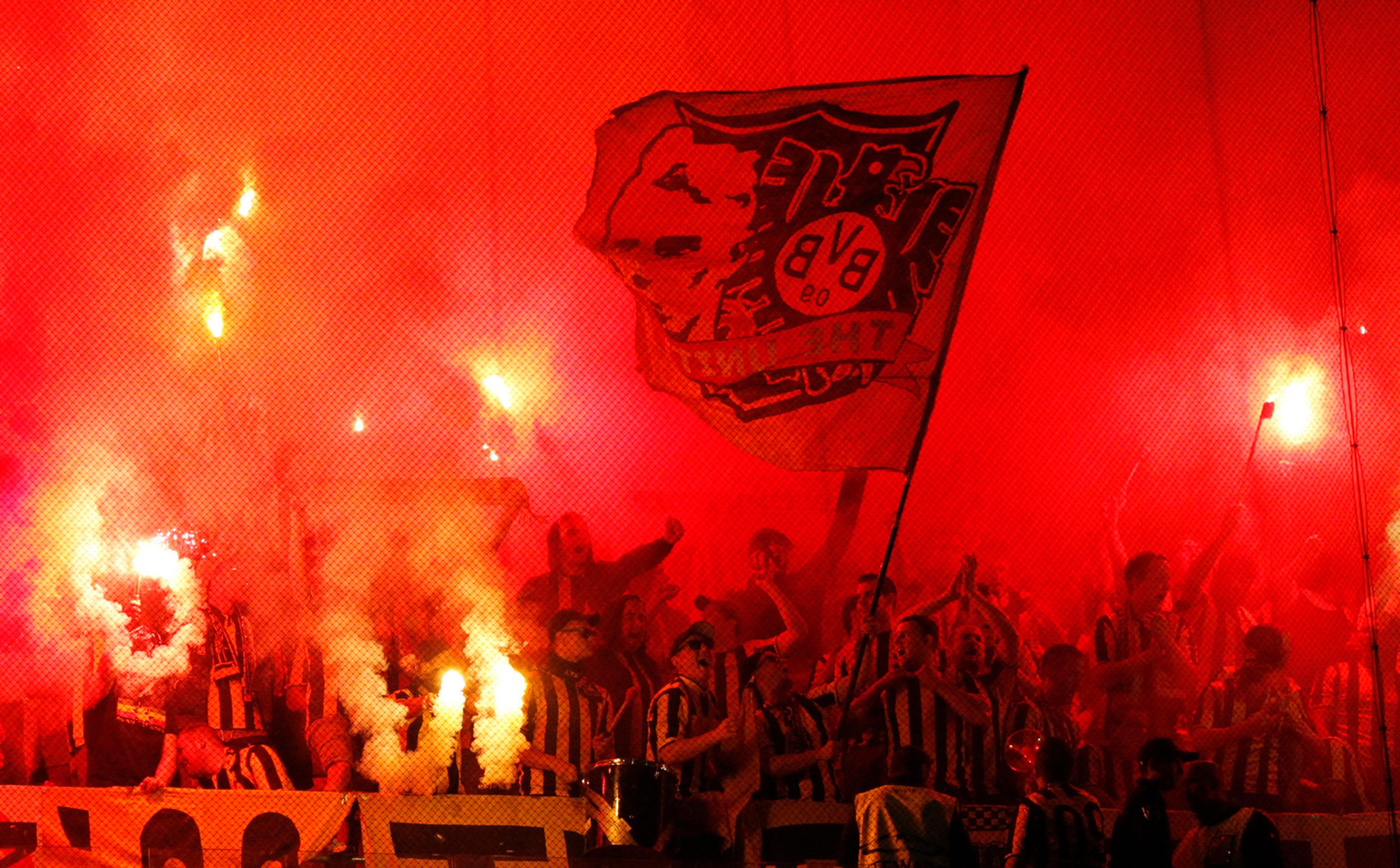 Priaznivci Dortmundu so svetlicami počas duelu LM v Lisabone proti Sportingu.