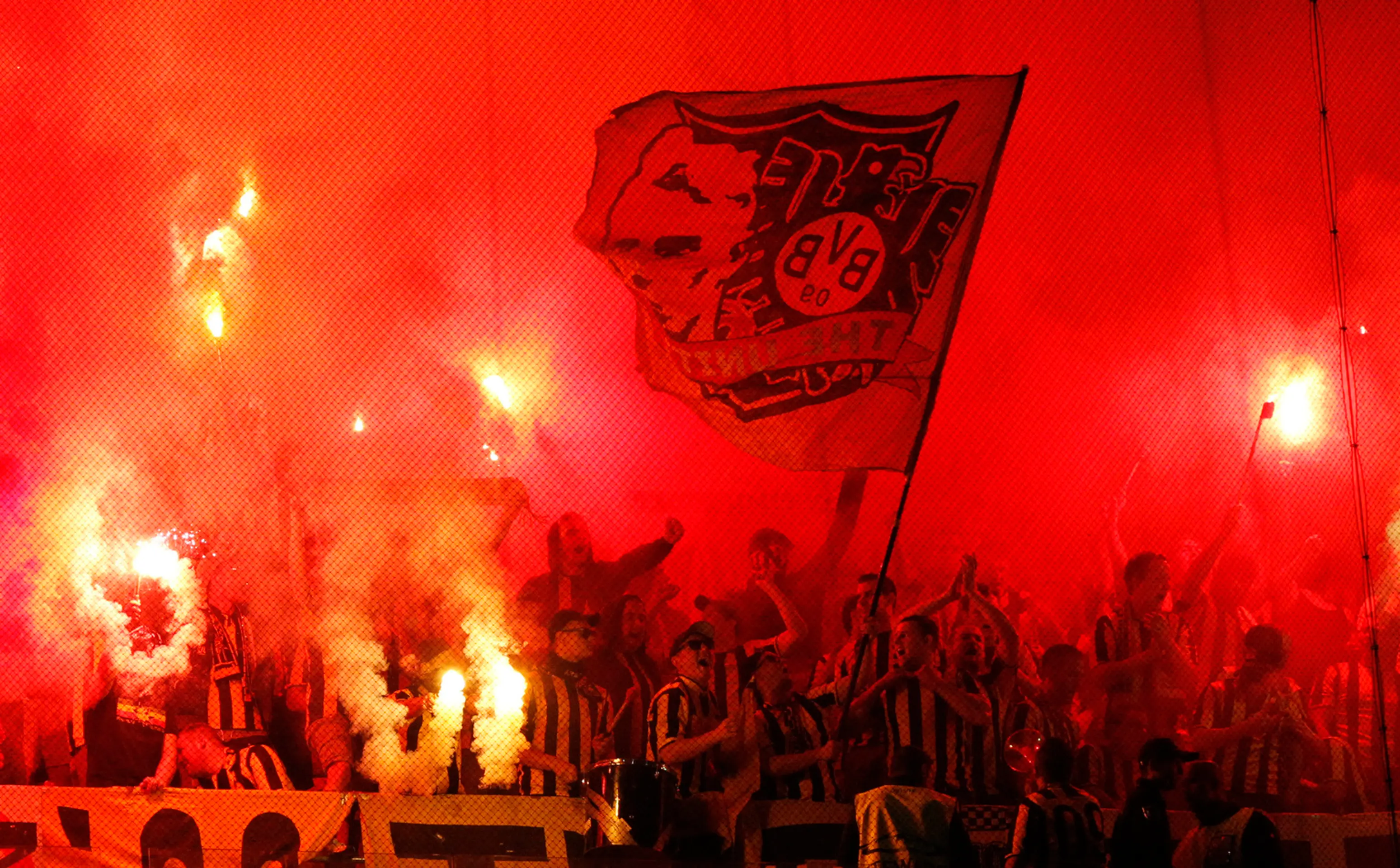 Priaznivci Dortmundu so svetlicami počas duelu LM v Lisabone proti Sportingu.
