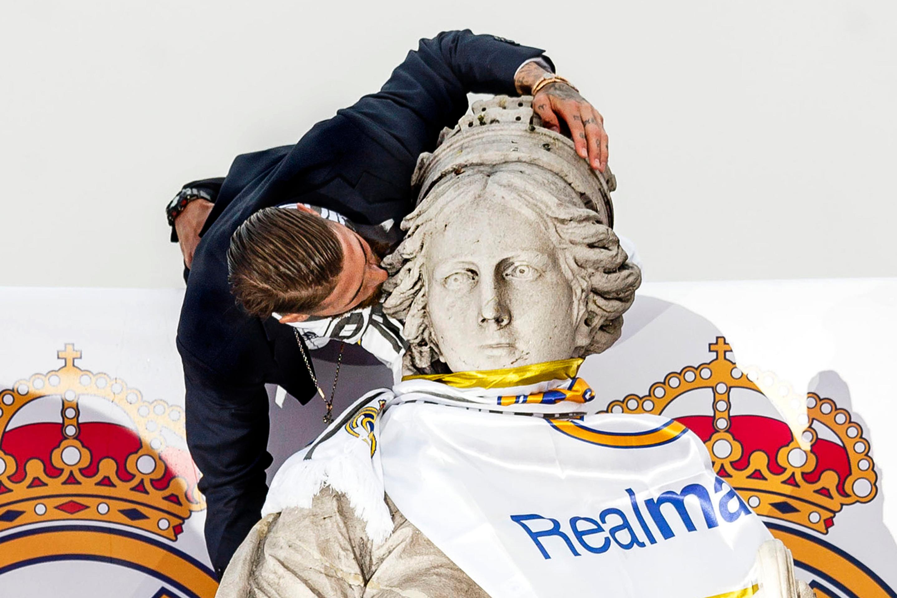Kapitán Realu Madrid Sergio Ramos bozkáva sochu na madridskom námestí Cibeles.