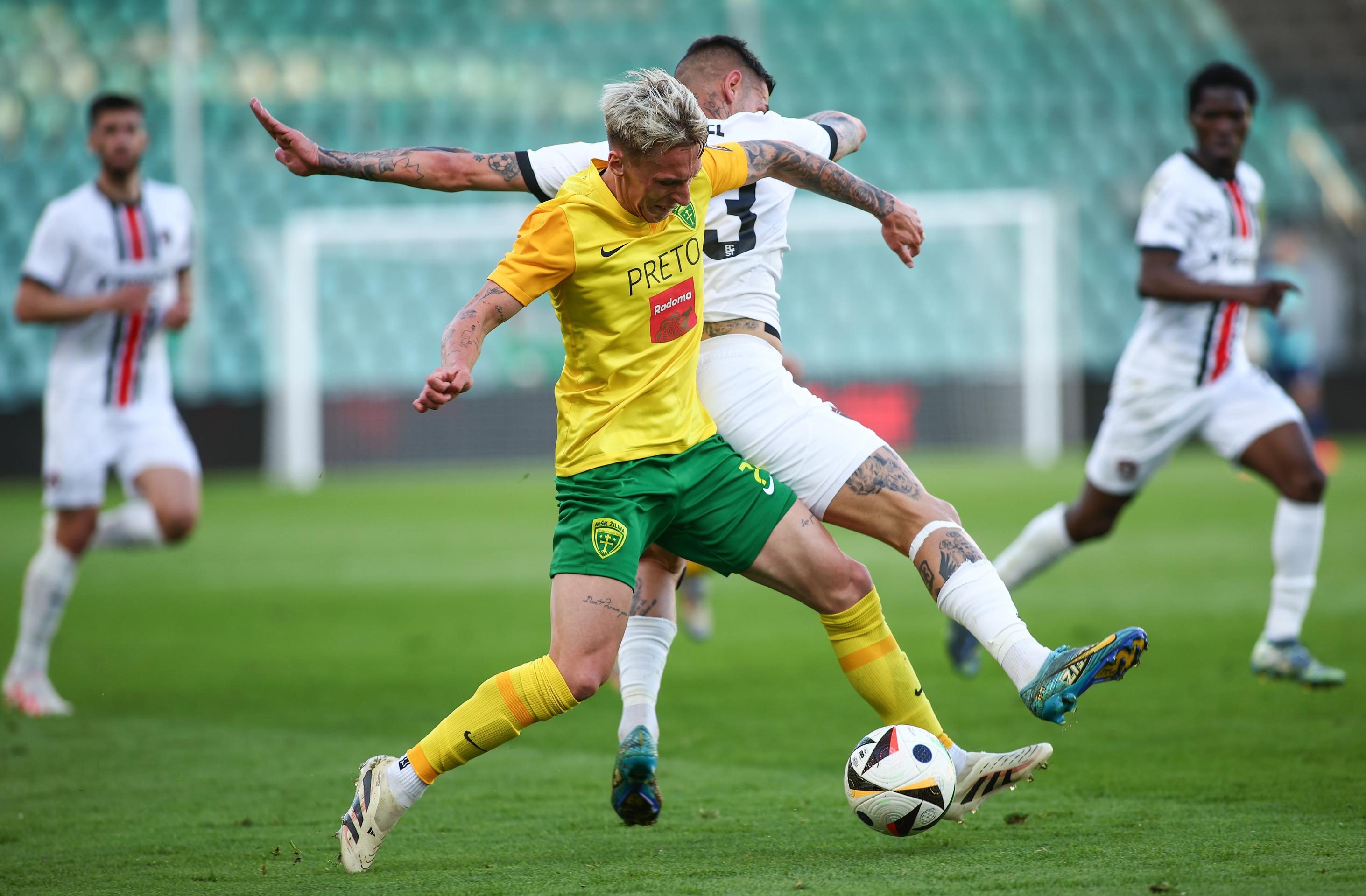 Uprostred zľava Samuel Ďatko (Žilina) a Erik Daniel (Trnava) bojujú o loptu v 7. kole nadstavby Niké ligy.