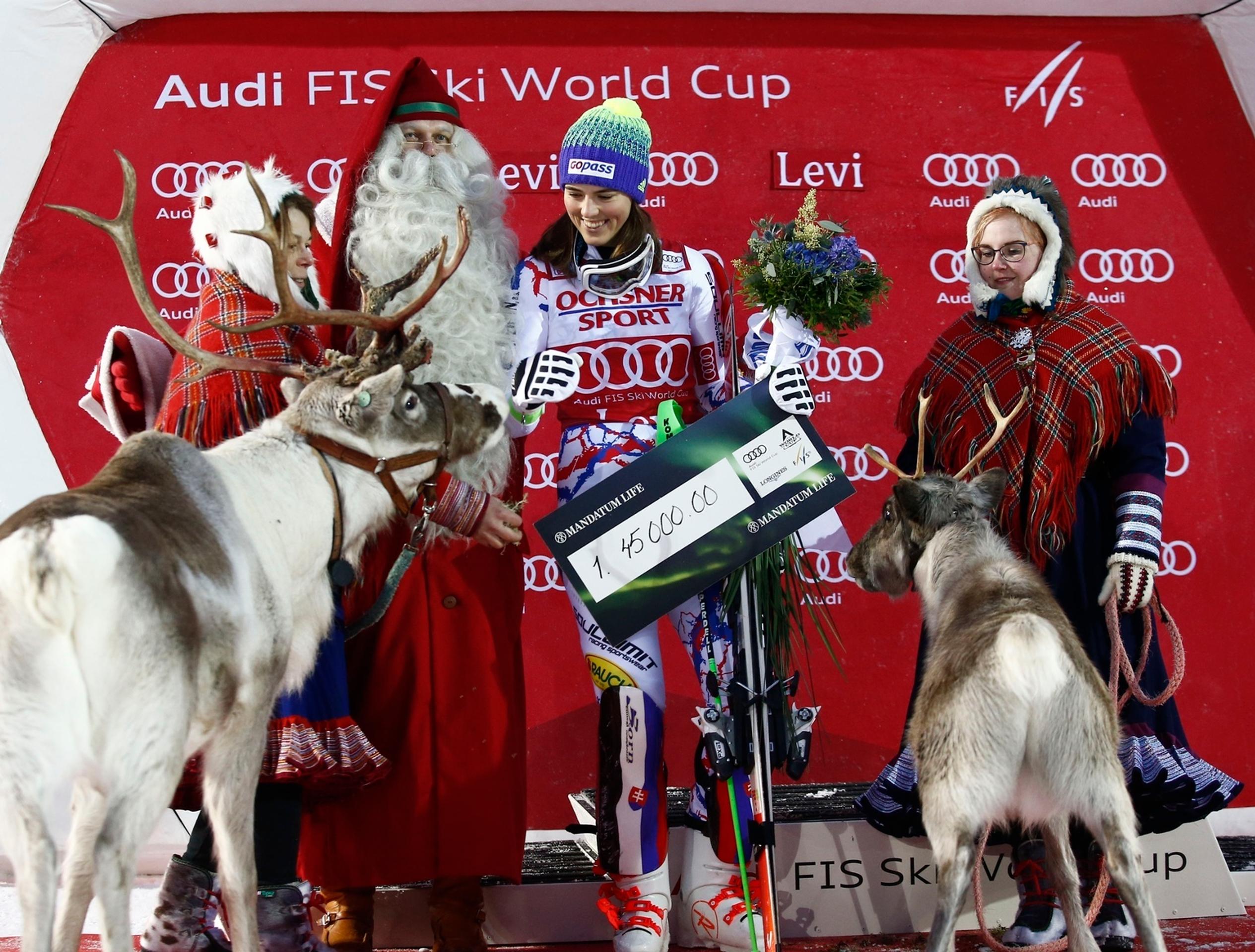 Petra Vlhová sa usmieva na pódiu so živými sobmi po prvom triumfe v slalome vo fínskom Levi z roku 2017.