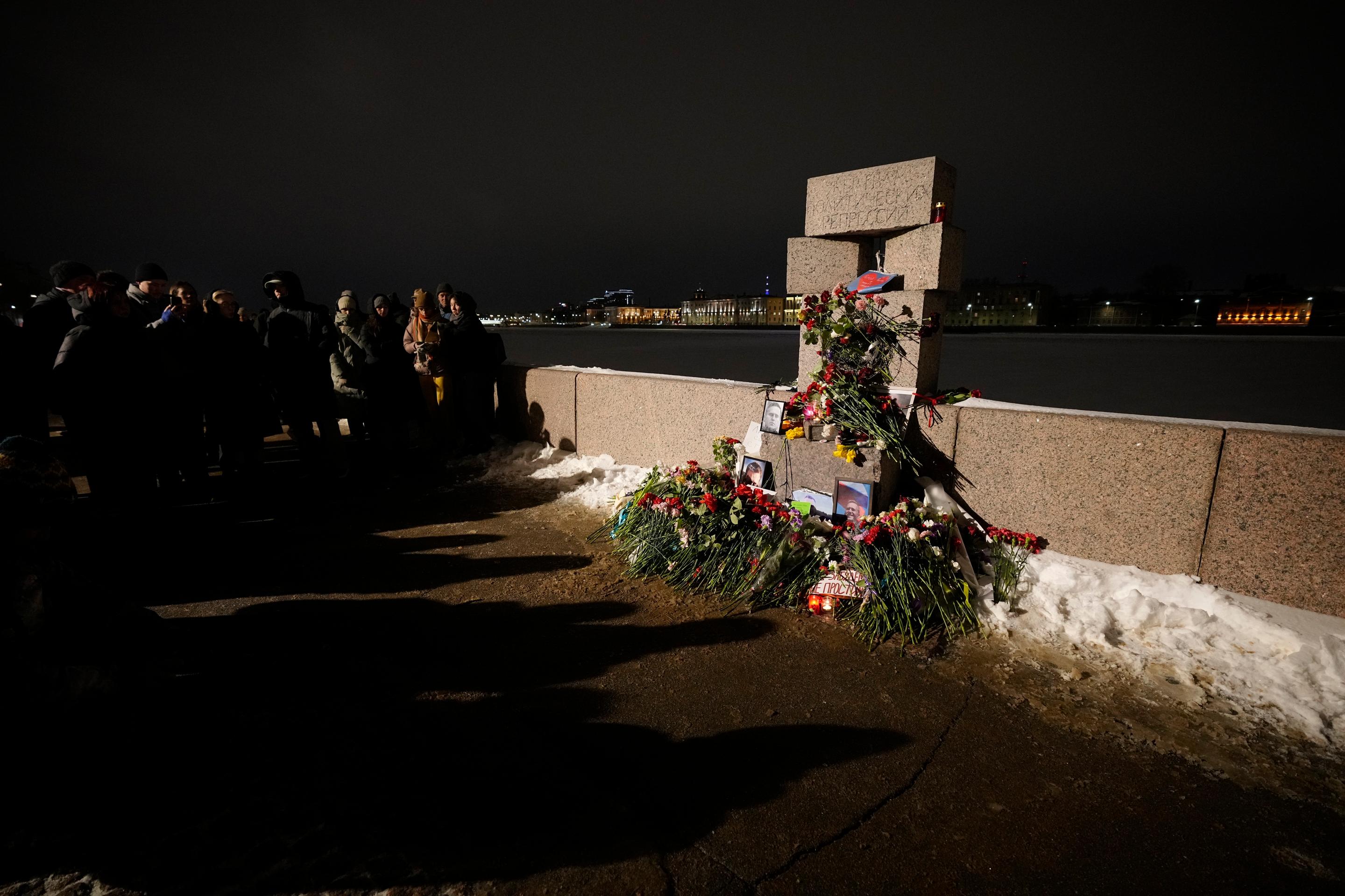 Ľudia kladú kvety k pamätníku obetí politických represií na v Petrohrade.