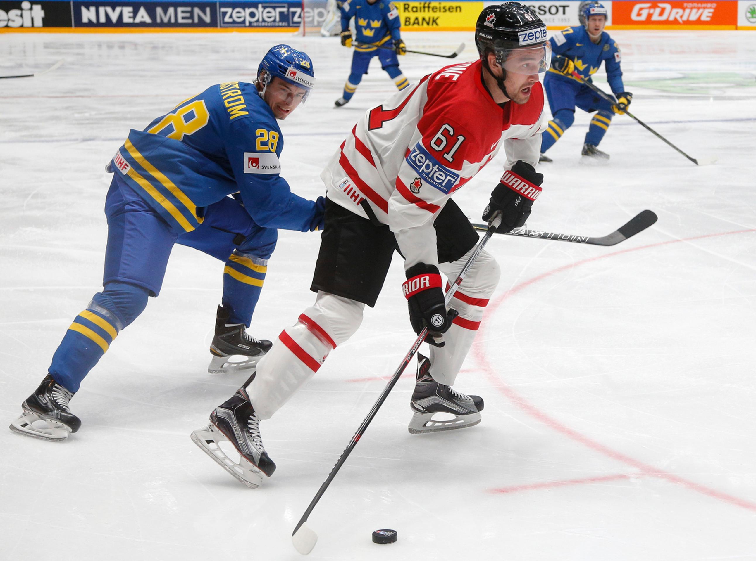 Švéd Johan Sundström (vľavo) a kanadský Mark Stone bojujú o puk vo štvrťfinále MS v Rusku.