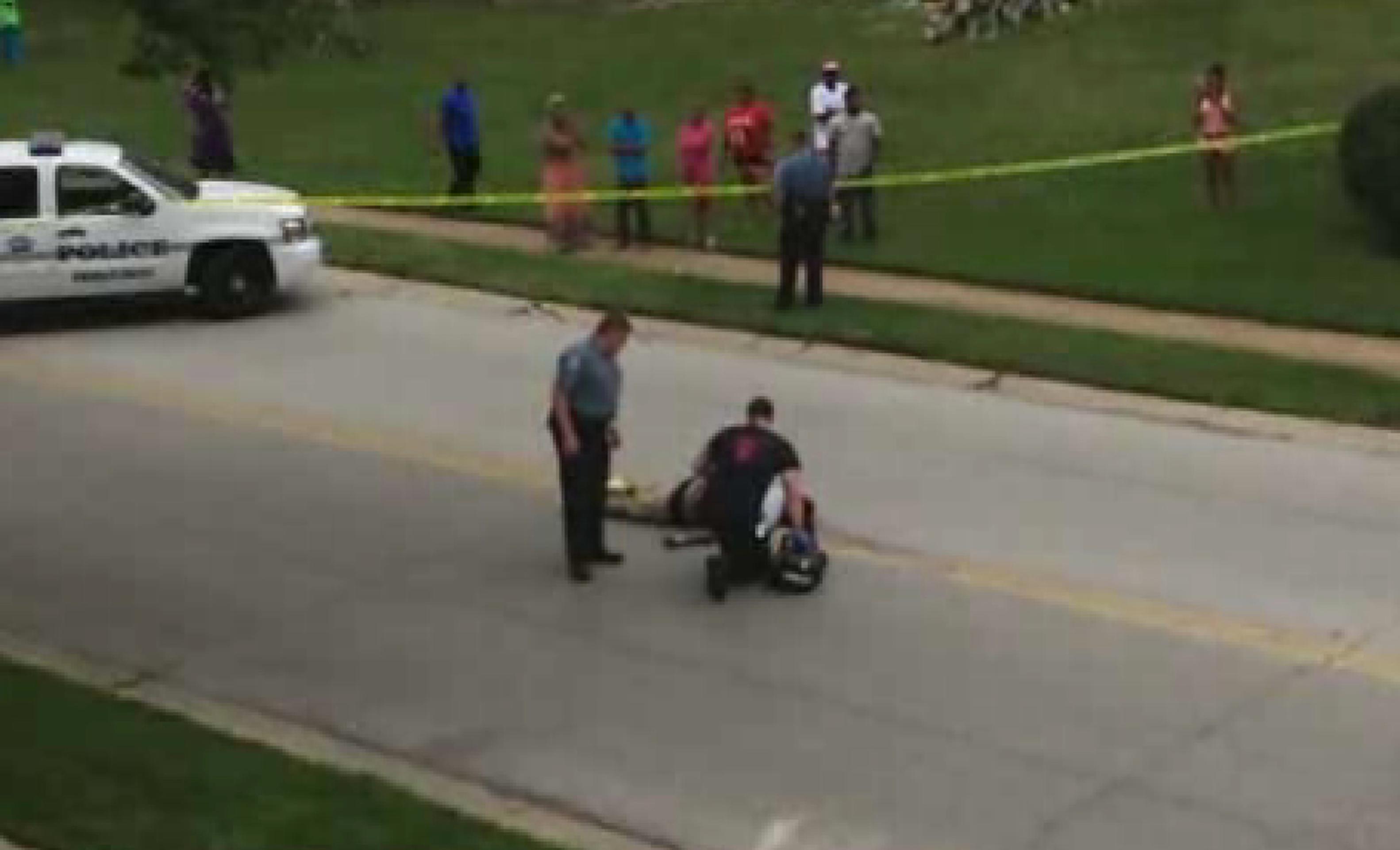 Na videosnímke z 9. augusta 2014 vyšetrovatelia kontrolujú telo Michaela Browna v americkom Fergusone.