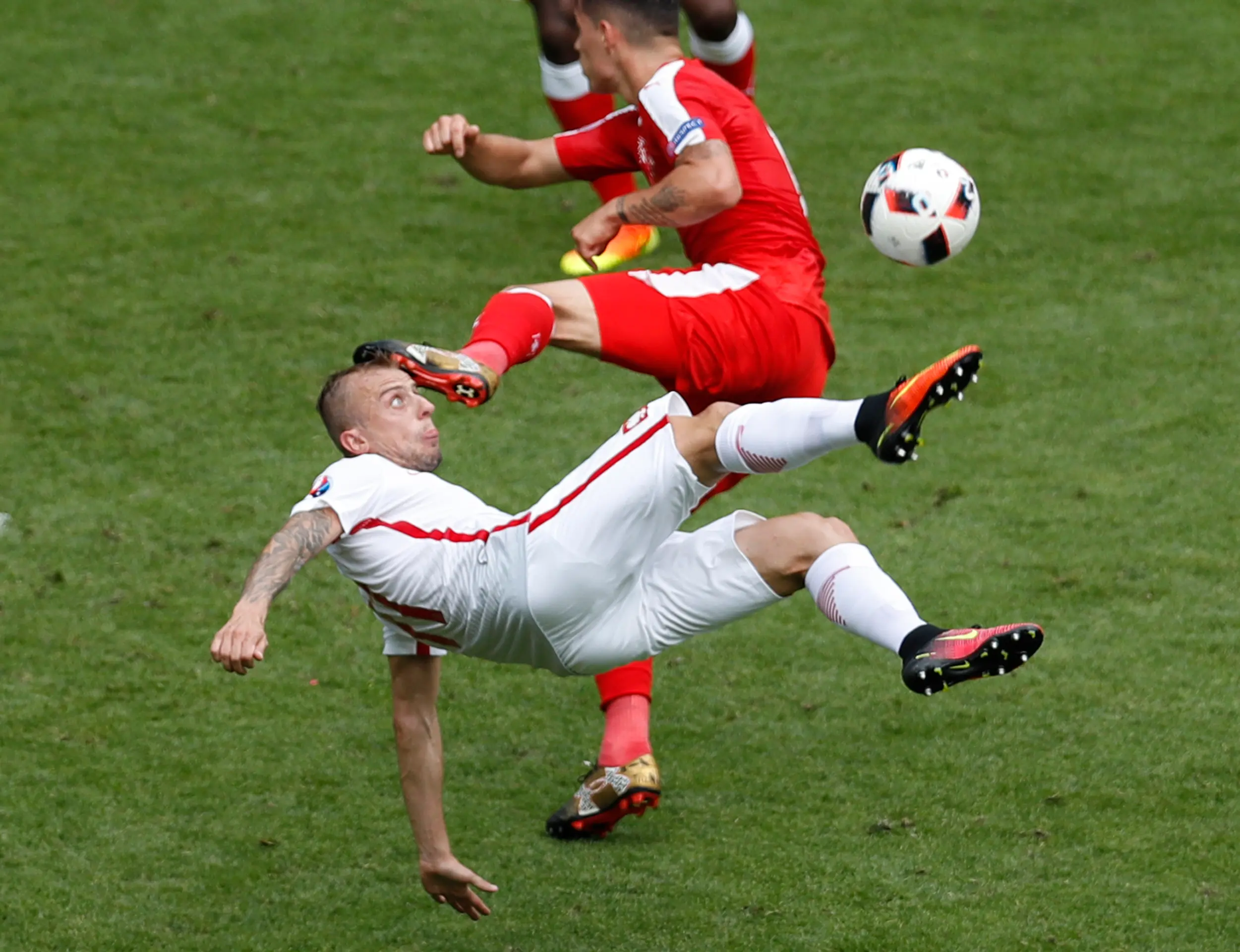 Hráč Poľska Kamil Grosicki pri akrobatickom pokuse o streľbu v osemfinále ME proti Švajčiarsku