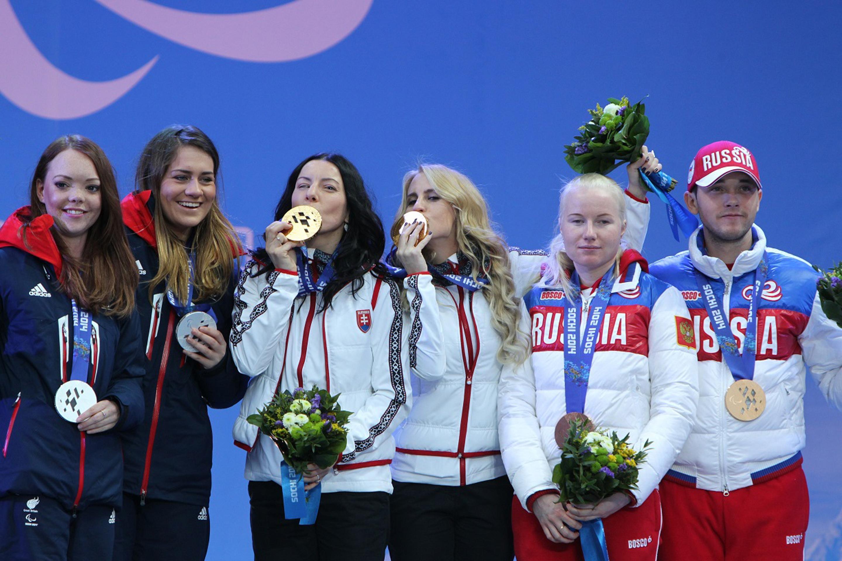 Zjazdová lyžiarka Henrieta Farkašová (uprostred vľavo) a jej navádzačka Natália Šubrtová (uprostred vpravo) tešiac sa zo zlatej 