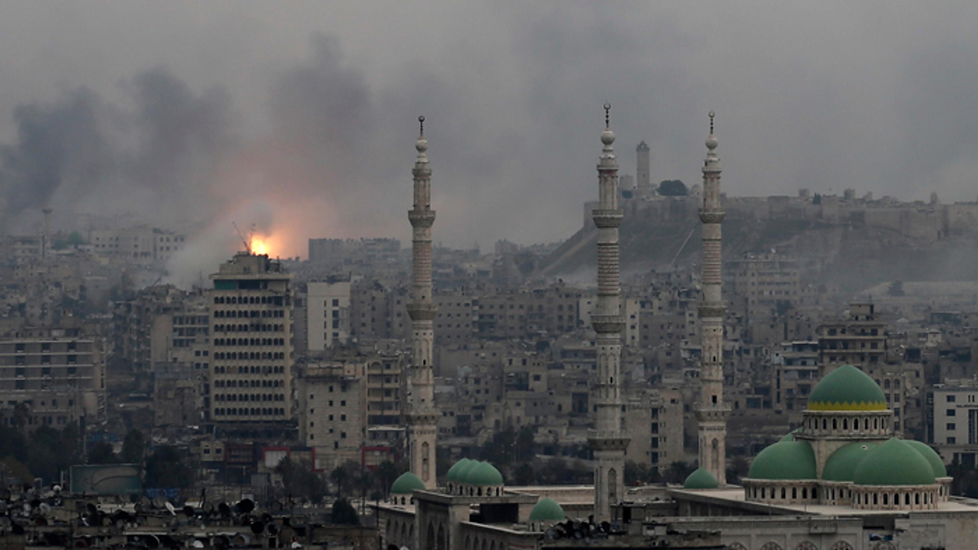 Dym a plamene stúpajú počas leteckých náletov sýrskych vládnych síl na rebelov na východe Aleppa.