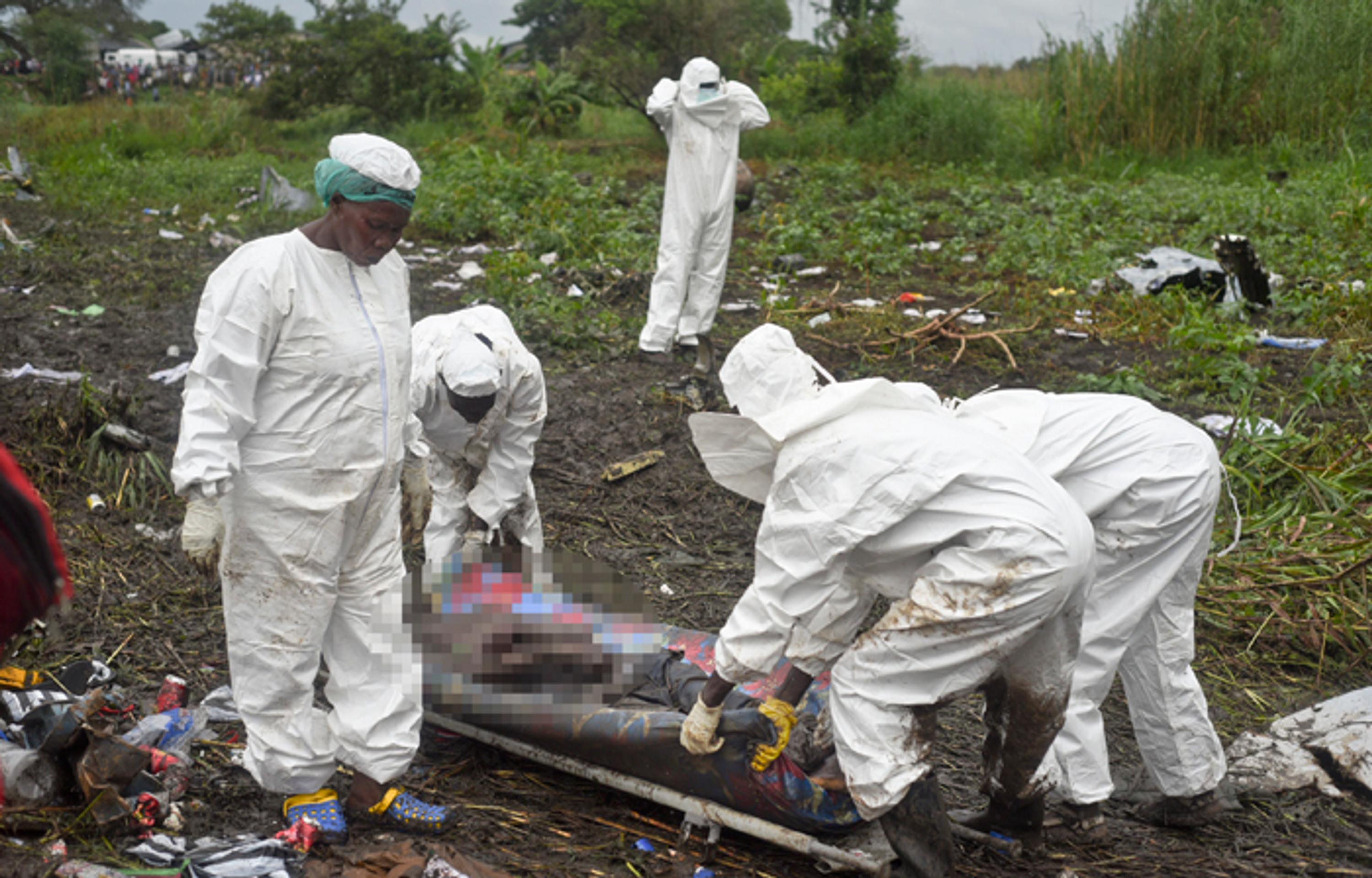Záchranári nakladajú mŕtve telo pasažiera z havarovaného lietadla pri meste Džuba.