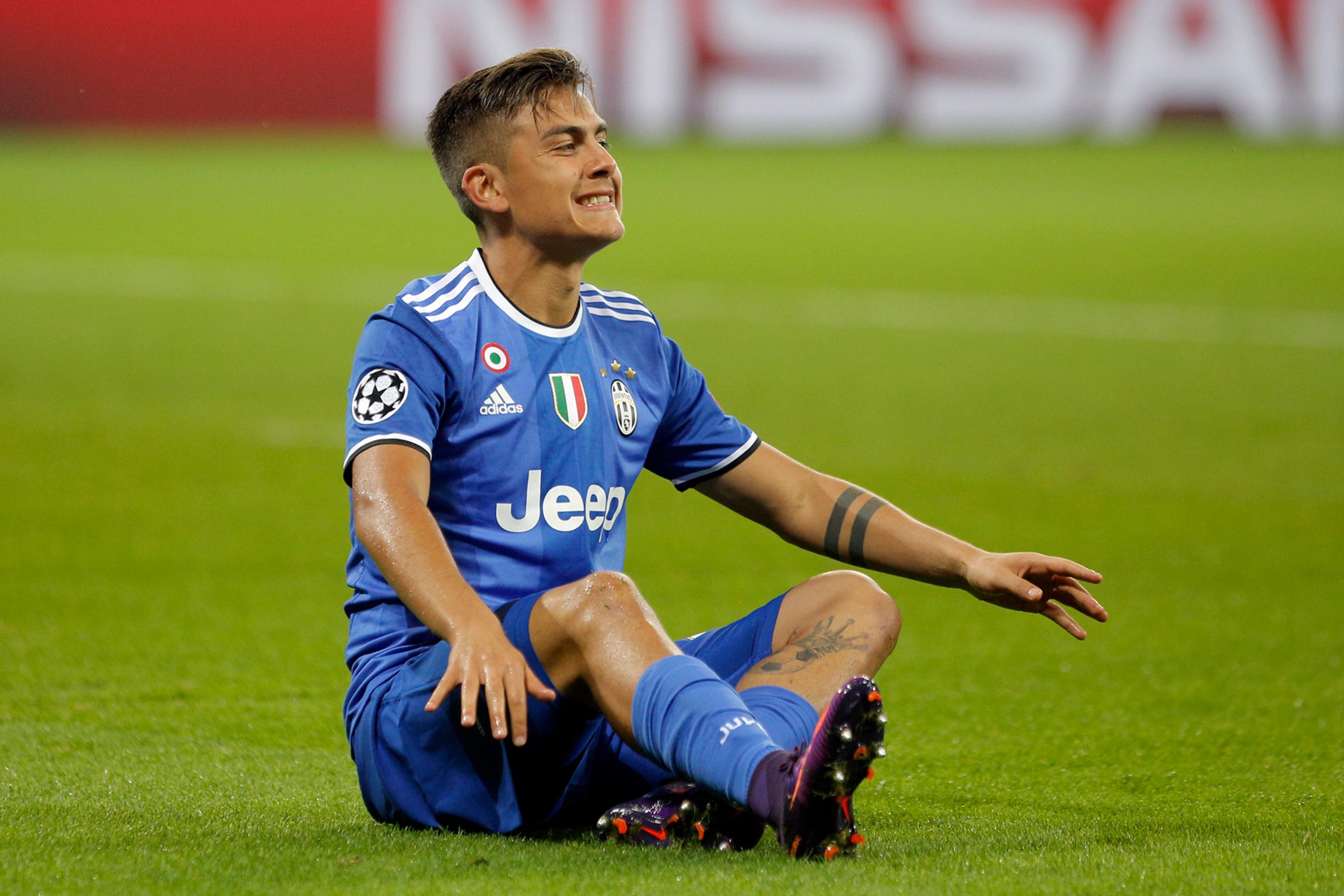 Kanonier Juventusu Psulo Dybala sedí na trávniku v Lyone počas duelu LM.