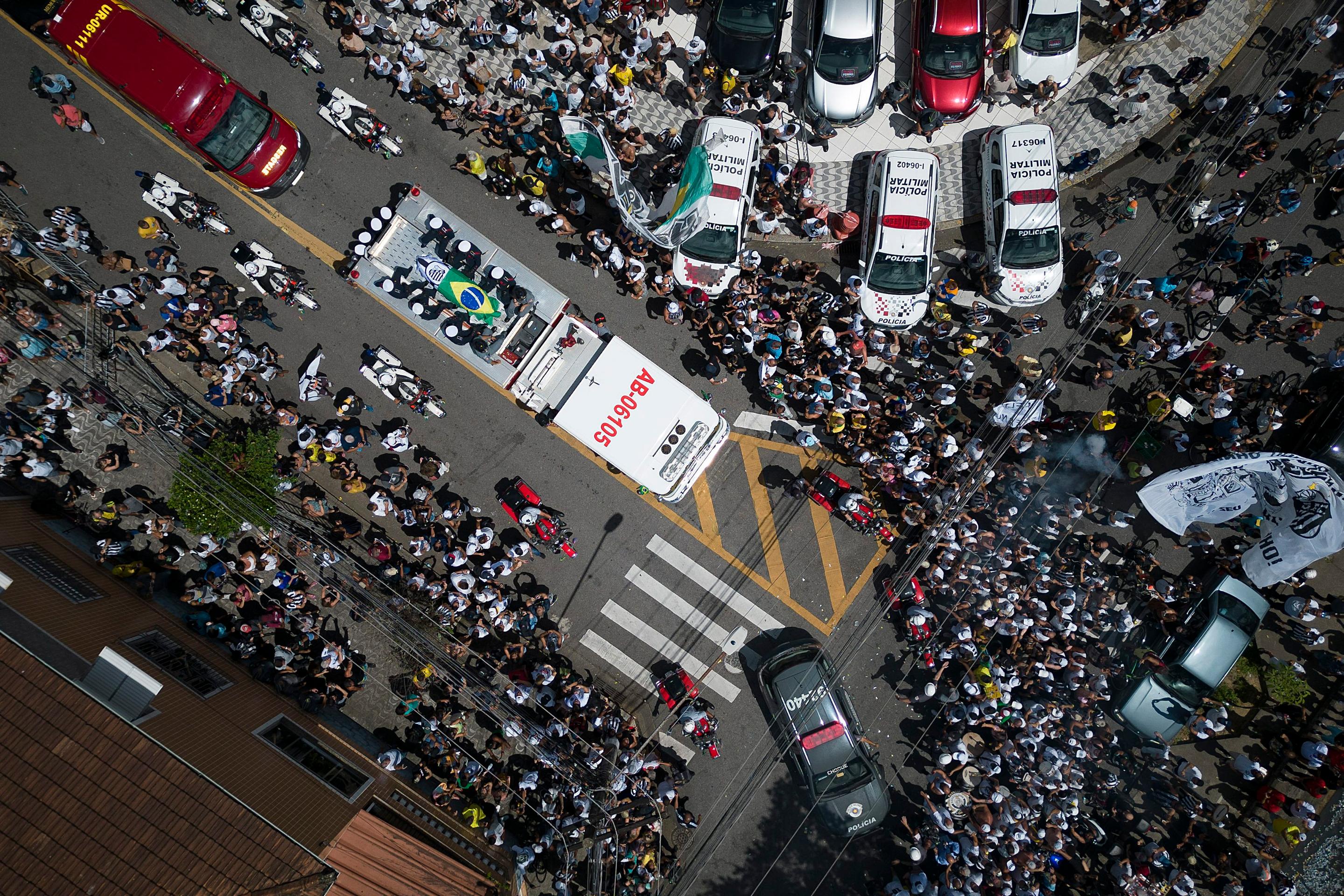 Rakva s pozostkami zosnulého brazílskeho legendárneho futbalistu Pelého je zakrytá brazílskou vlajkou a vlajkou klubu Santos FC počas prevozu zo štadióna Vila Belmiro na cintorín Memorial Necropole Ecumenica.