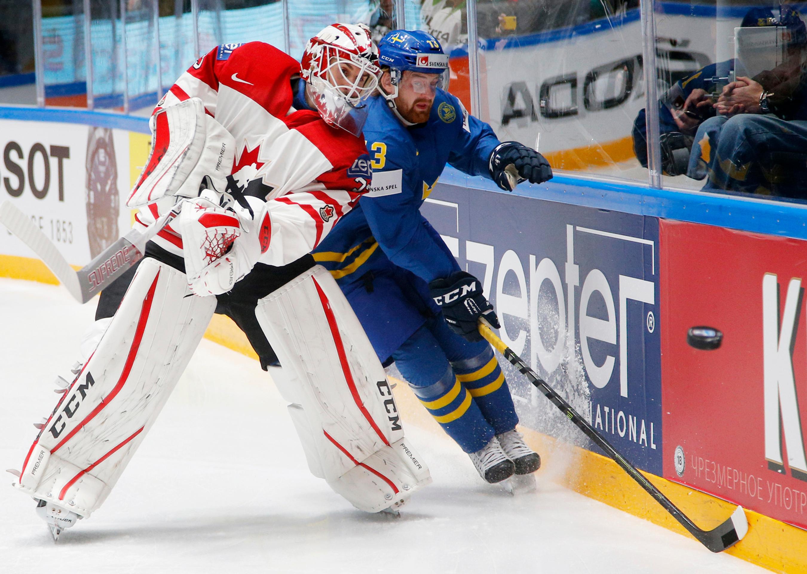 Švéd Mattias Ritola (vpravo) a kanadský brankár Cam Talbot bojujú o puk pri mantineli vo štvrťfinále MS v Rusku.